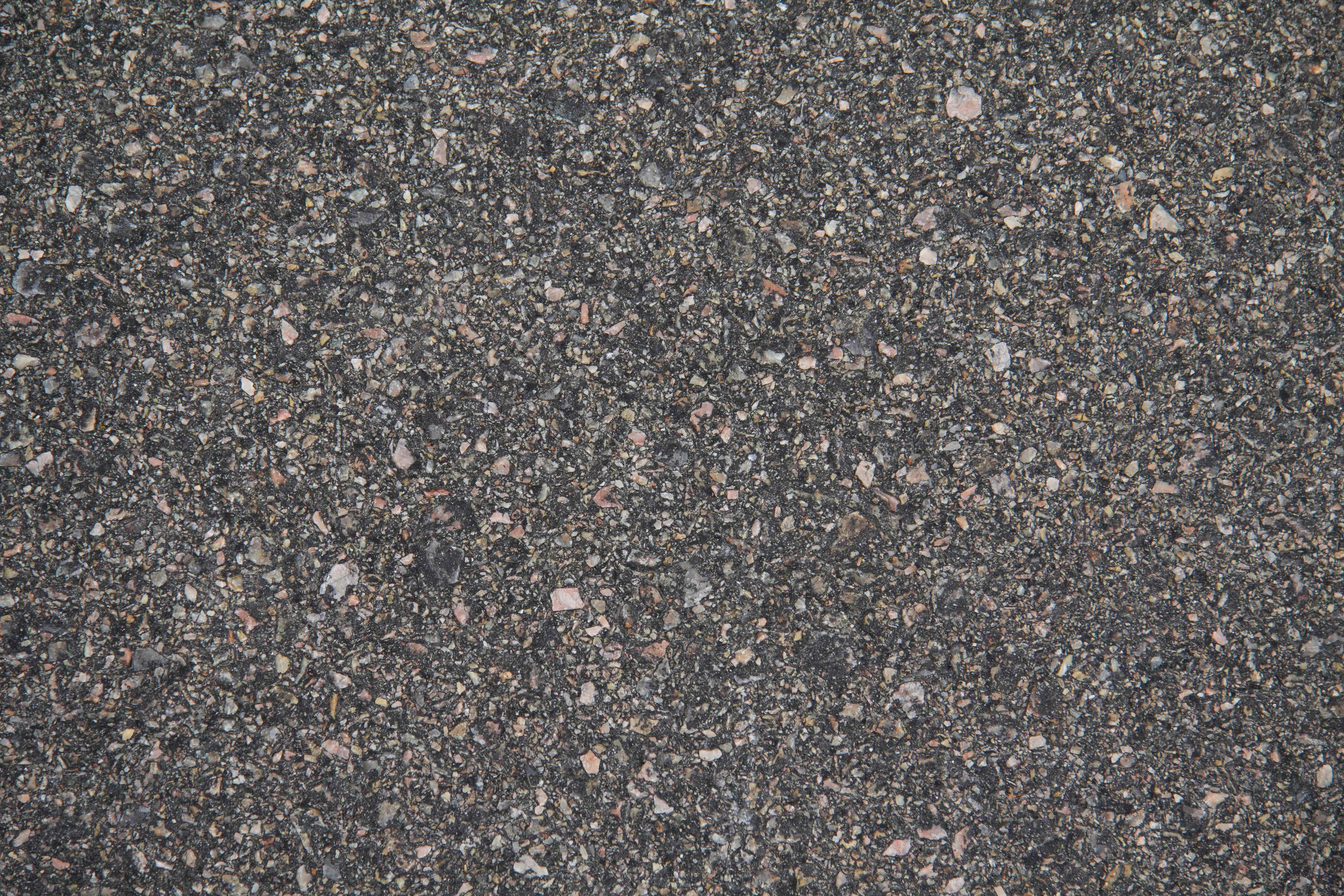 Concrete Texture 桌布 壁紙 — 粗糙瀝青路面的特寫，內嵌灰褐色和粉紅色礫石。