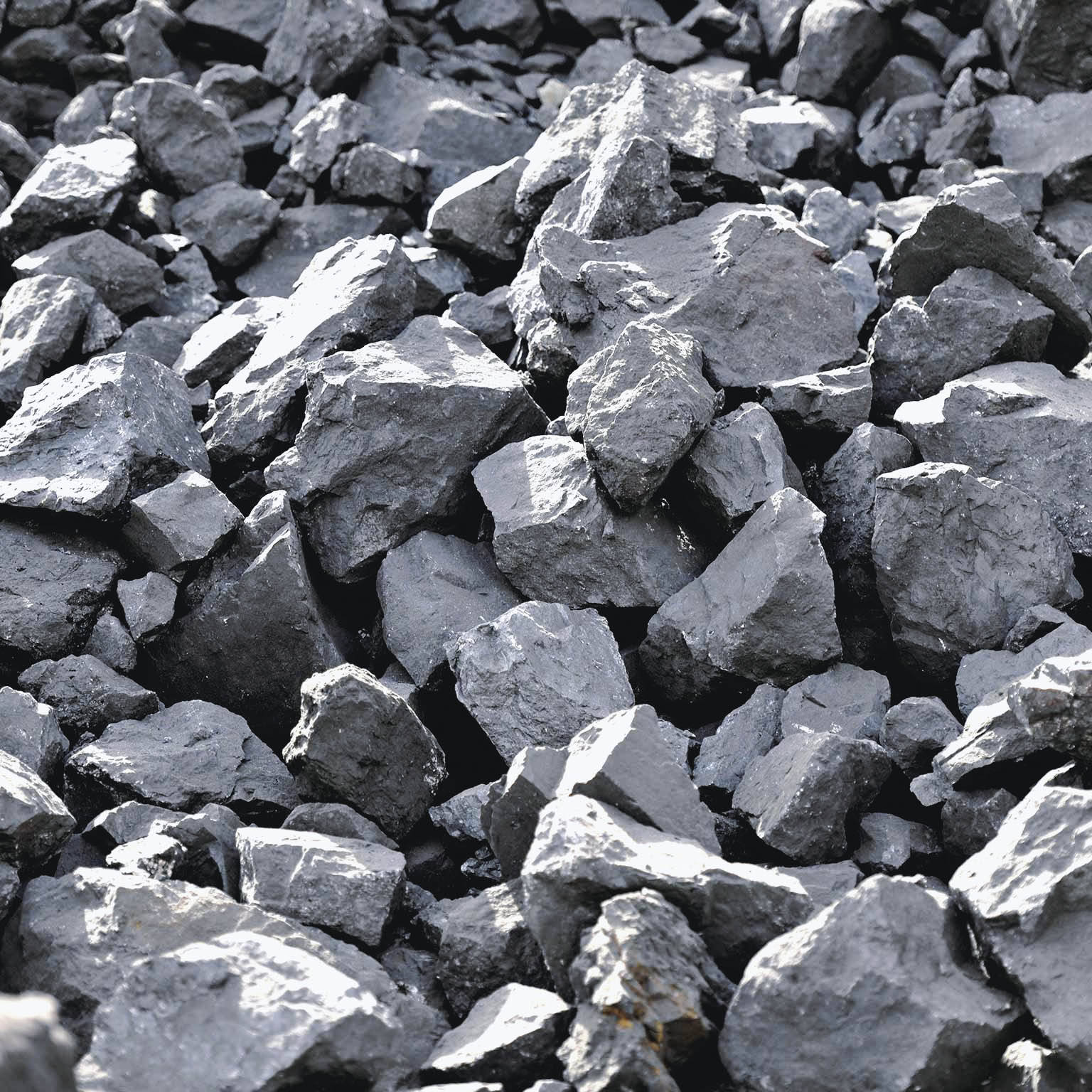 Rock 桌布 壁紙 — 粗糙灰色木炭塊的特寫，堆疊在一起，邊緣鋒利，表面有紋理。