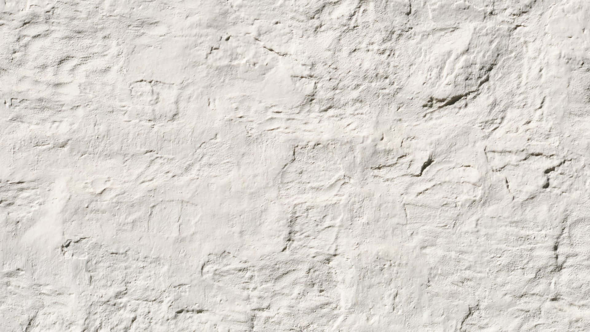 Textured 桌布 壁紙 — 粗糙白色灰泥牆的特寫，紋理不均勻，帶有微妙的灰色陰影。