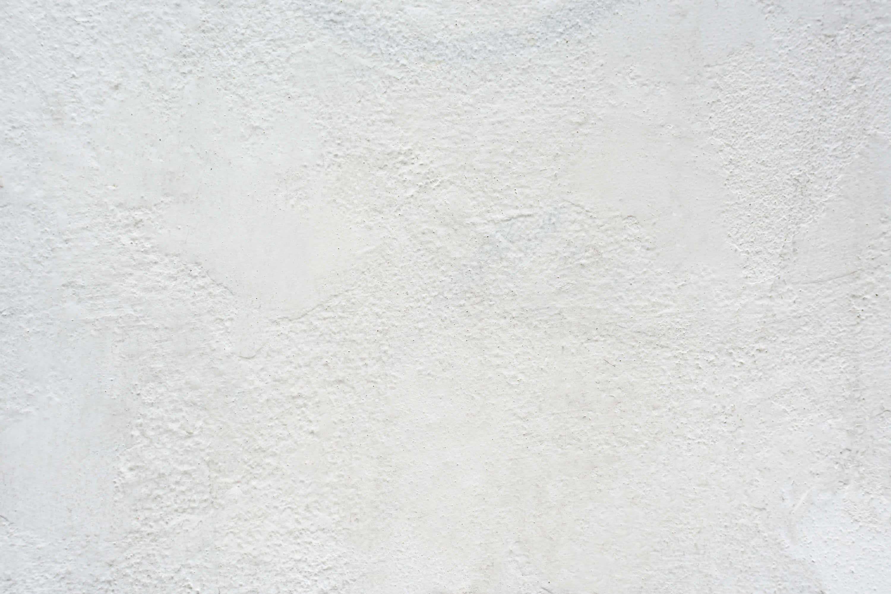 Rough Texture 桌布 壁紙 — 粗糙白色灰泥牆的近距離特寫，帶有微妙的紋理變化和柔和光線。