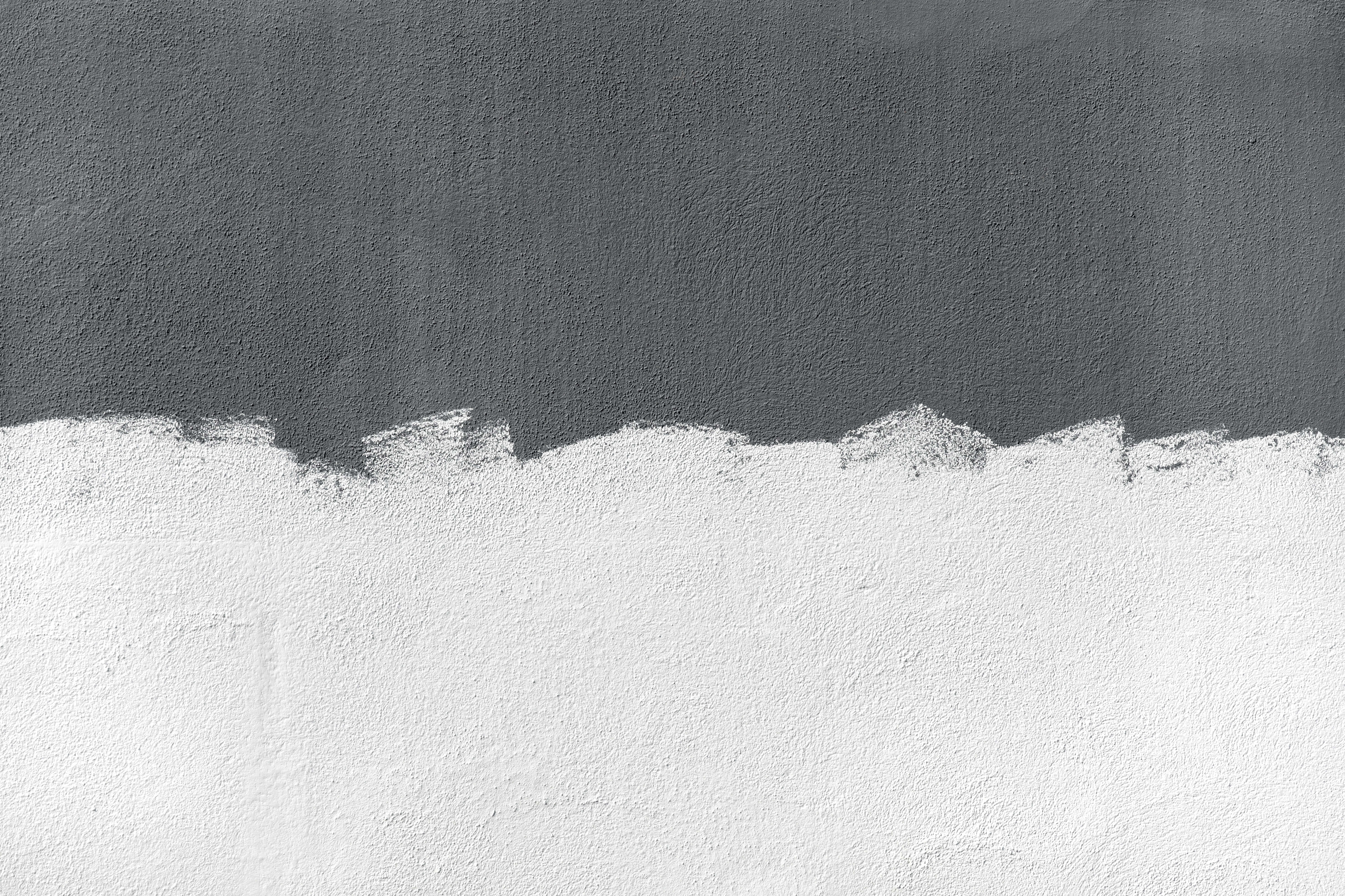 Minimalist Gray 桌布 壁紙 — 粗糙白色灰泥與深灰色紋理牆壁形成鮮明對比，邊緣呈鋸齒狀。