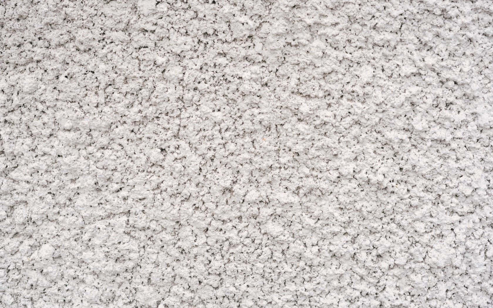 Rough Texture 桌布 壁紙 — 粗糙白色紋理表面的特寫，帶有顆粒細節和微妙的灰色底色。