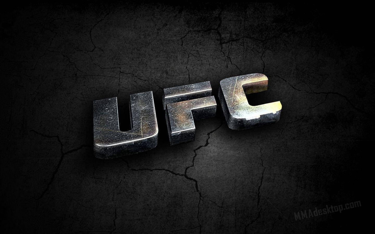 MMA 桌布 壁紙 — 粗糙的金屬UFC標誌放置在裂開的深色牆壁上，戲劇性的燈光突顯其堅韌的質感。
