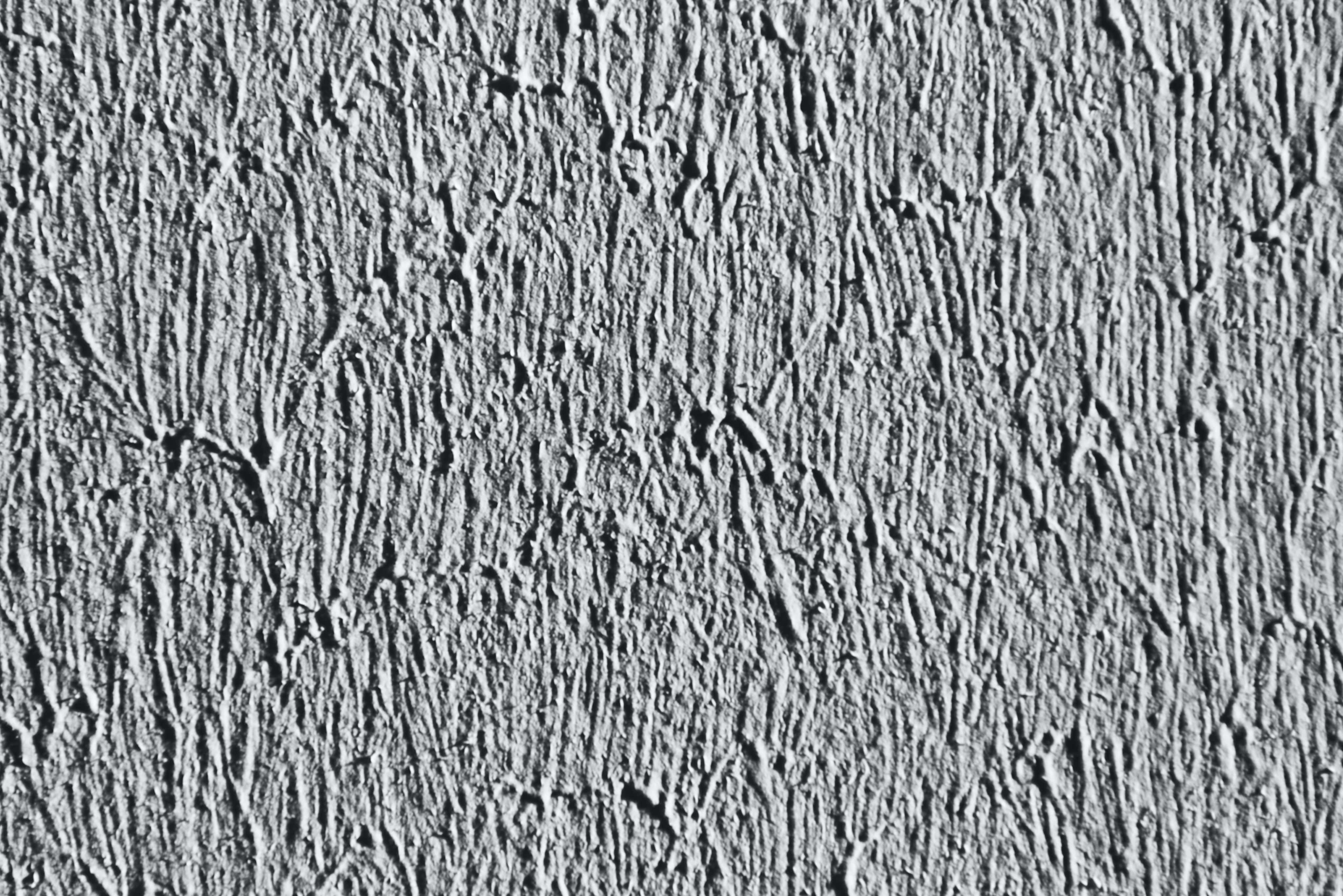 Gray Texture 桌布 壁紙 — 粗糙紋理灰色灰泥牆的特寫，帶有深垂直凹槽和微妙陰影。