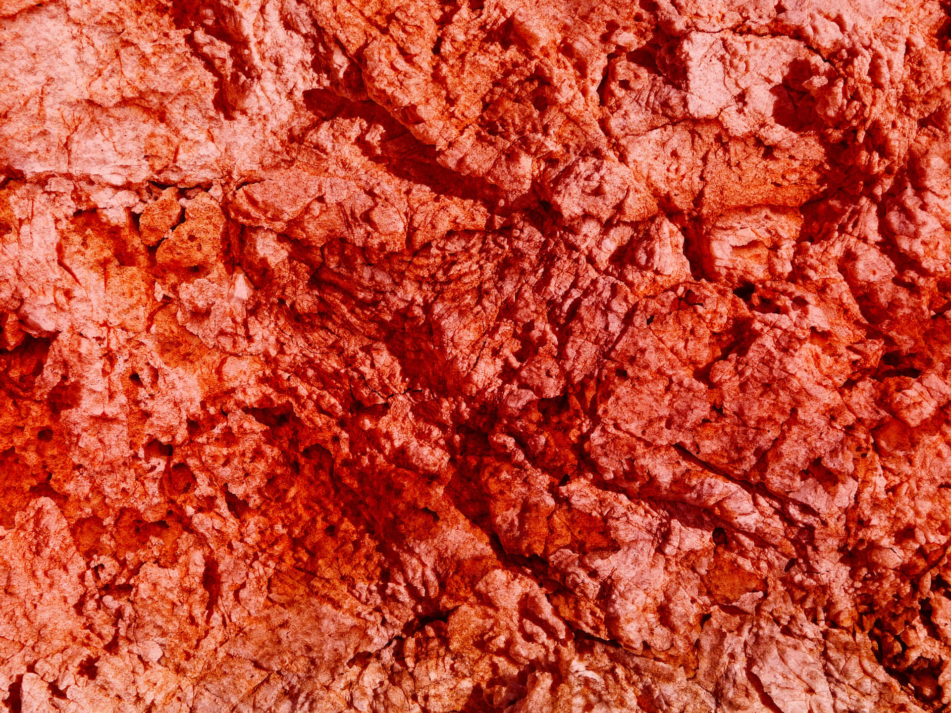 Red stone texture 壁紙 — 粗糙紋理的紅橙色岩石表面特寫，帶有深裂縫和不均勻的脊線。