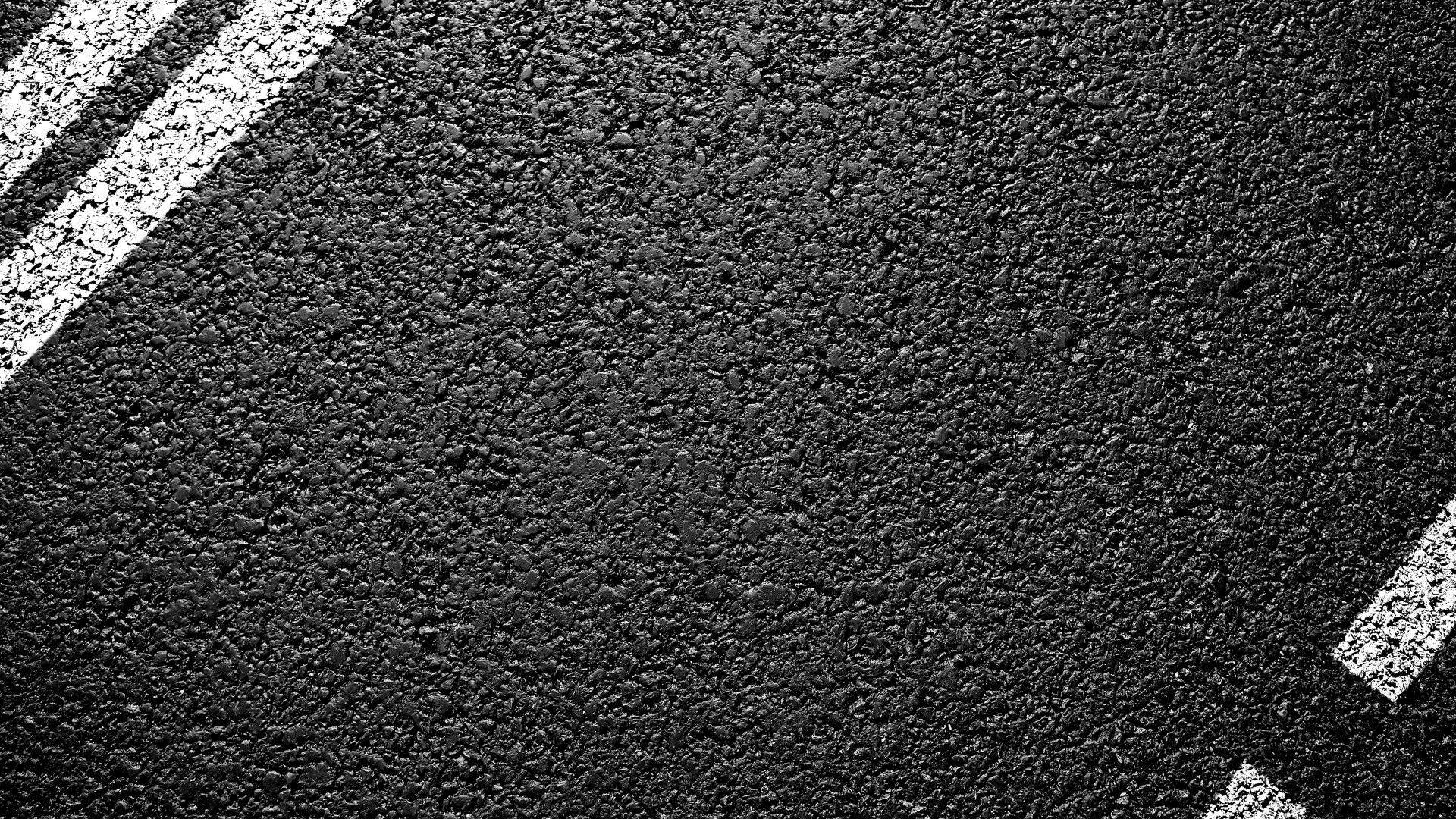 texture 桌布 壁紙 — 粗糙黑色瀝青路面近距離特寫，帶有對角白色油漆線條。