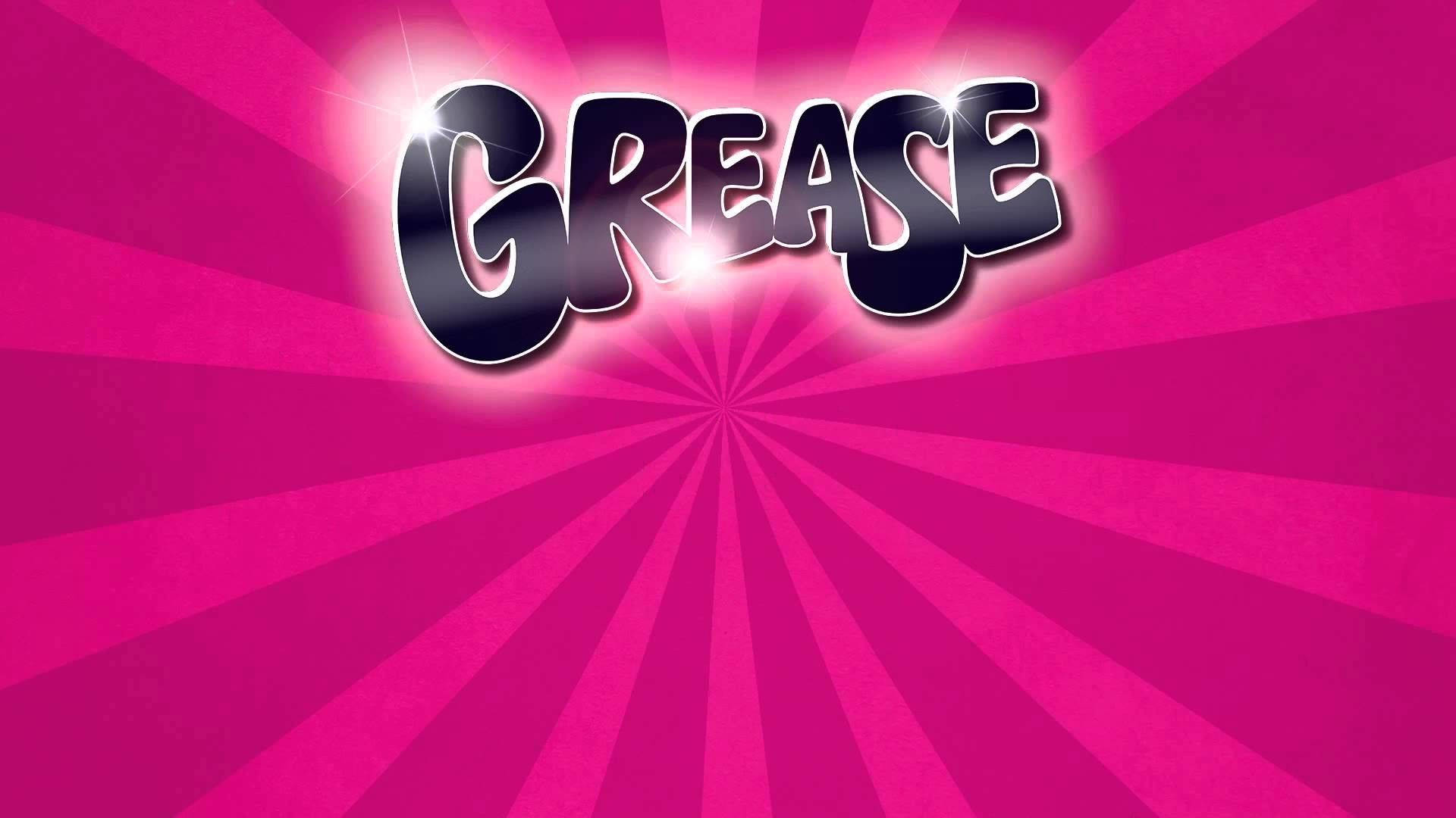 Grease 桌布 壁紙 — 粗體「GREASE」標誌在充滿活力的粉紅色放射狀爆發背景上閃爍著光芒。