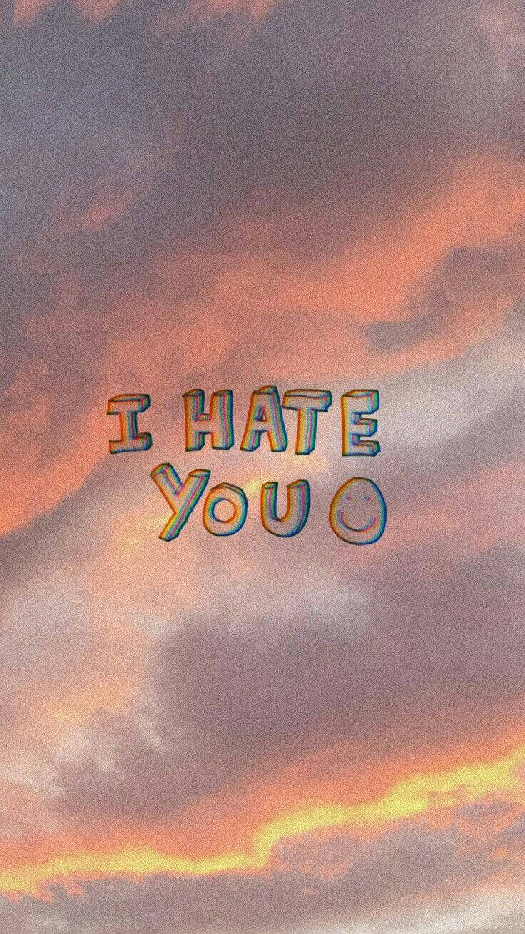 I Hate You 桌布 壁紙 — 粗體卡通文字「I HATE YOU」漂浮在戲劇性的日落天空上，帶有橙色、粉紅色和紫色的雲彩。