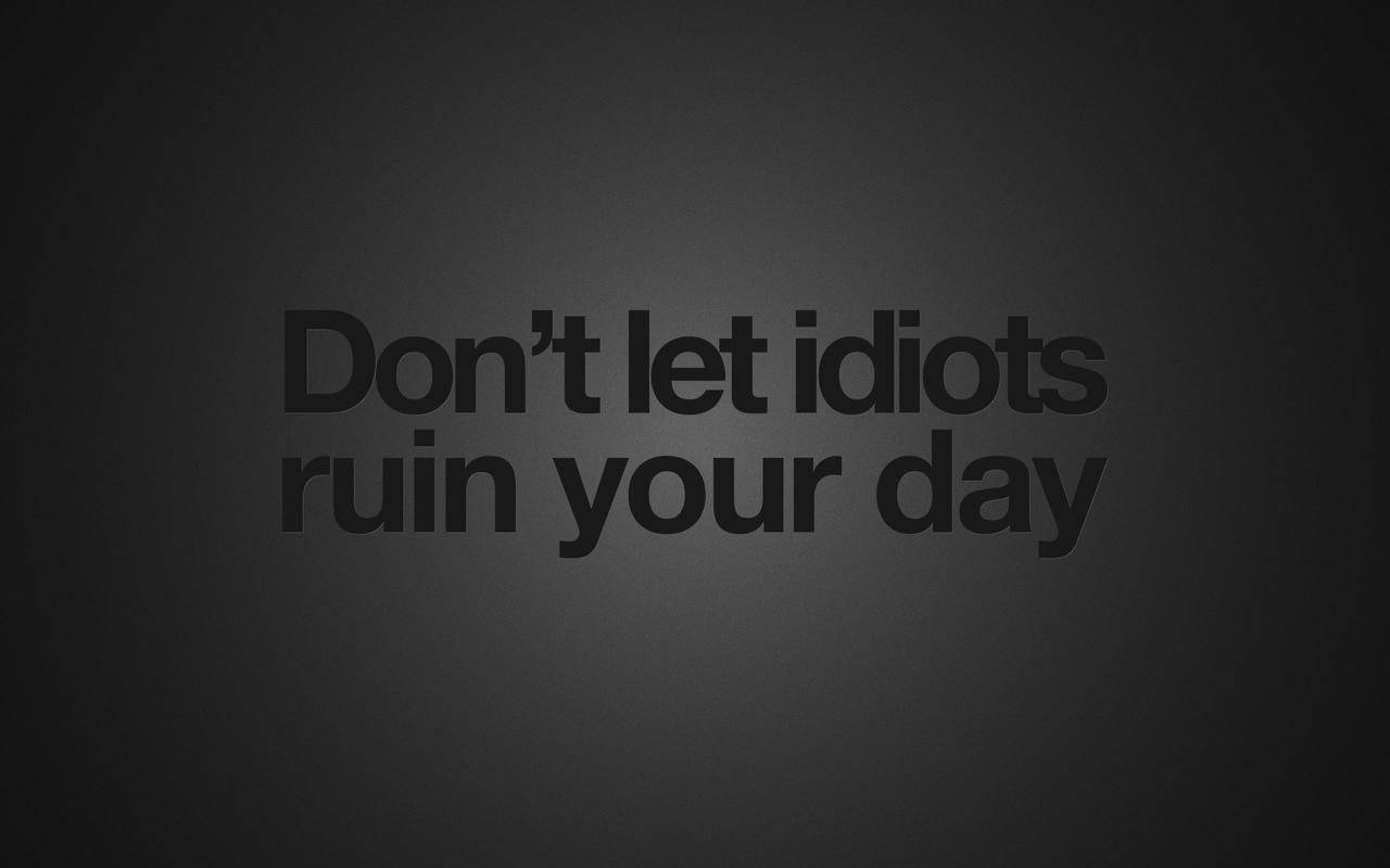黑色 桌布 壁紙 — 粗體文字寫著「Don't let idiots ruin your day」，居中顯示在深色漸變背景上。
