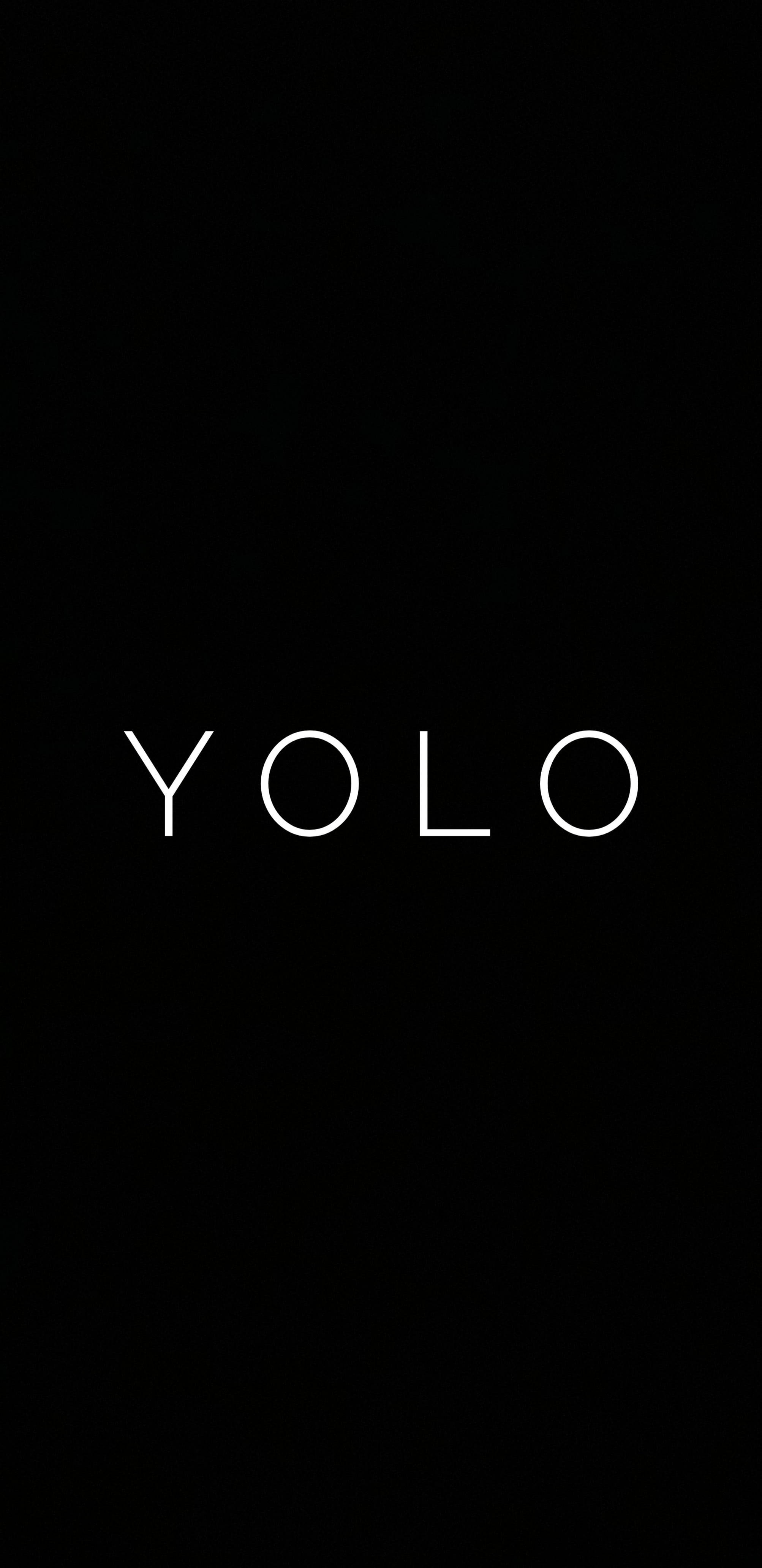 黑色 桌布 壁紙 — 粗體白色 'YOLO' 文字居中在純黑色背景上，營造出極簡的勵志語句。