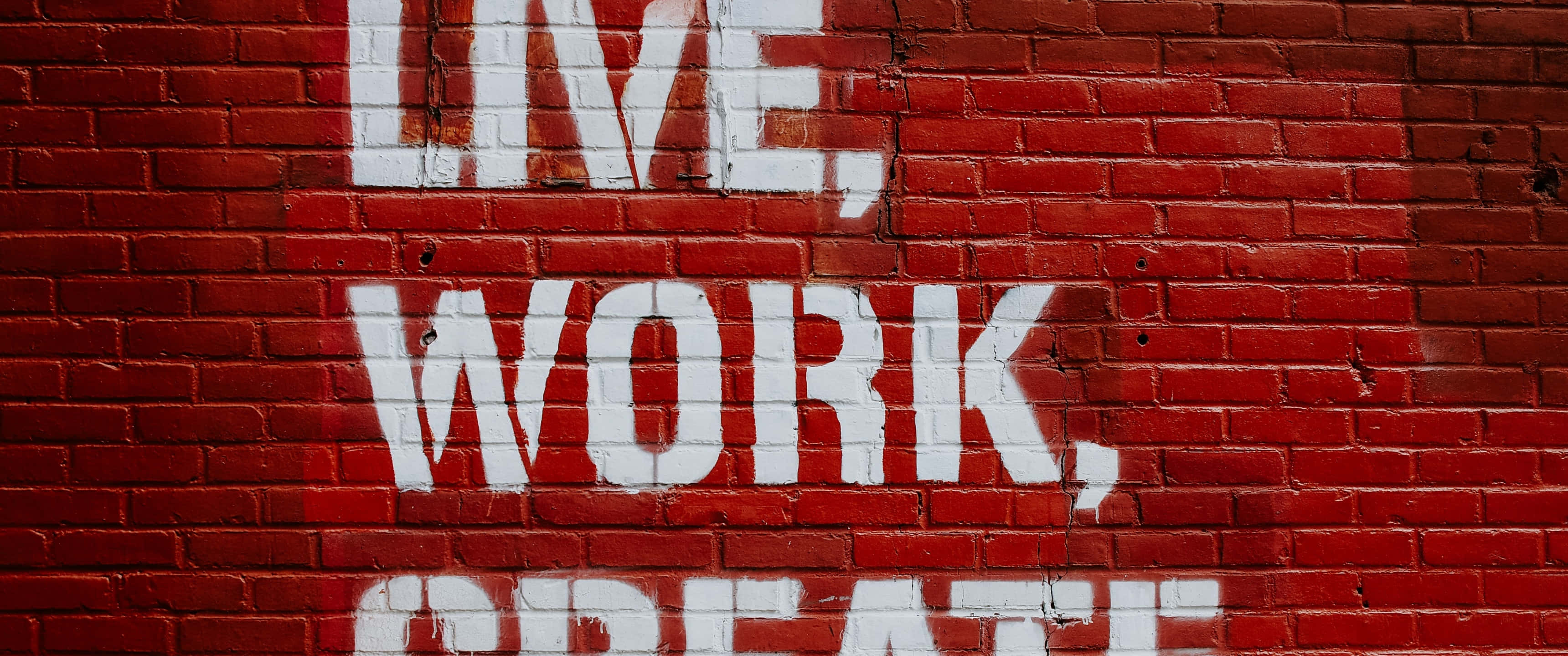 桌布 壁紙 — 粗體白色塗鴉字母在風化的紅磚牆上拼出 live work create。