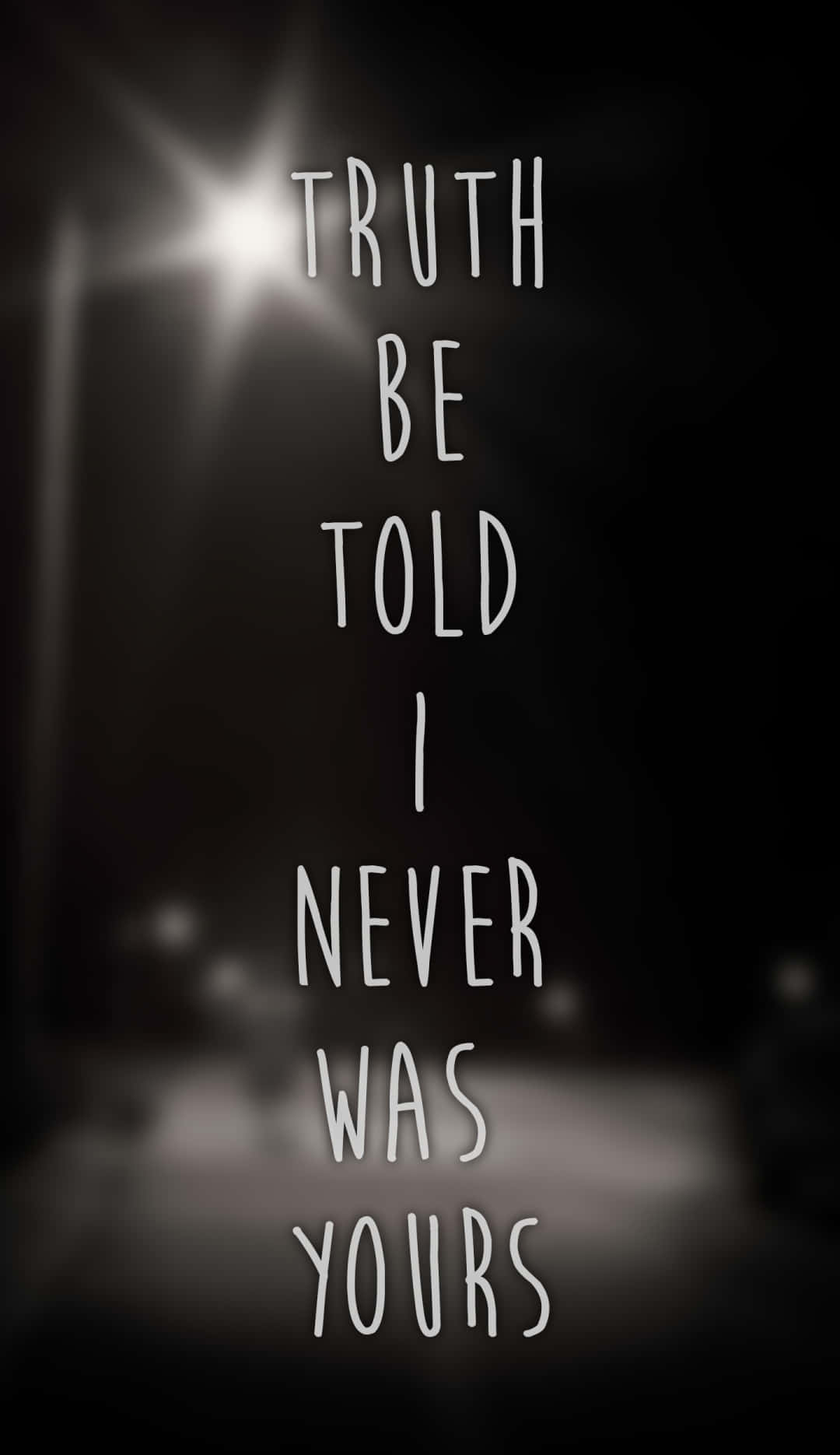 Gospel 桌布 壁紙 — 粗體白色手寫文字「TRUTH BE TOLD I NEVER WAS YOURS」映襯在昏暗模糊的夜晚街道上，帶有明亮的街燈光暈。