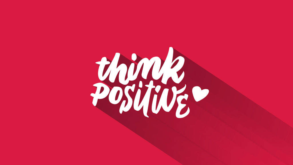 Positive 桌布 壁紙 — 粗體白色手寫文字寫著「think positive」，帶有心形圖標，在鮮紅色背景上投下長長的陰影。