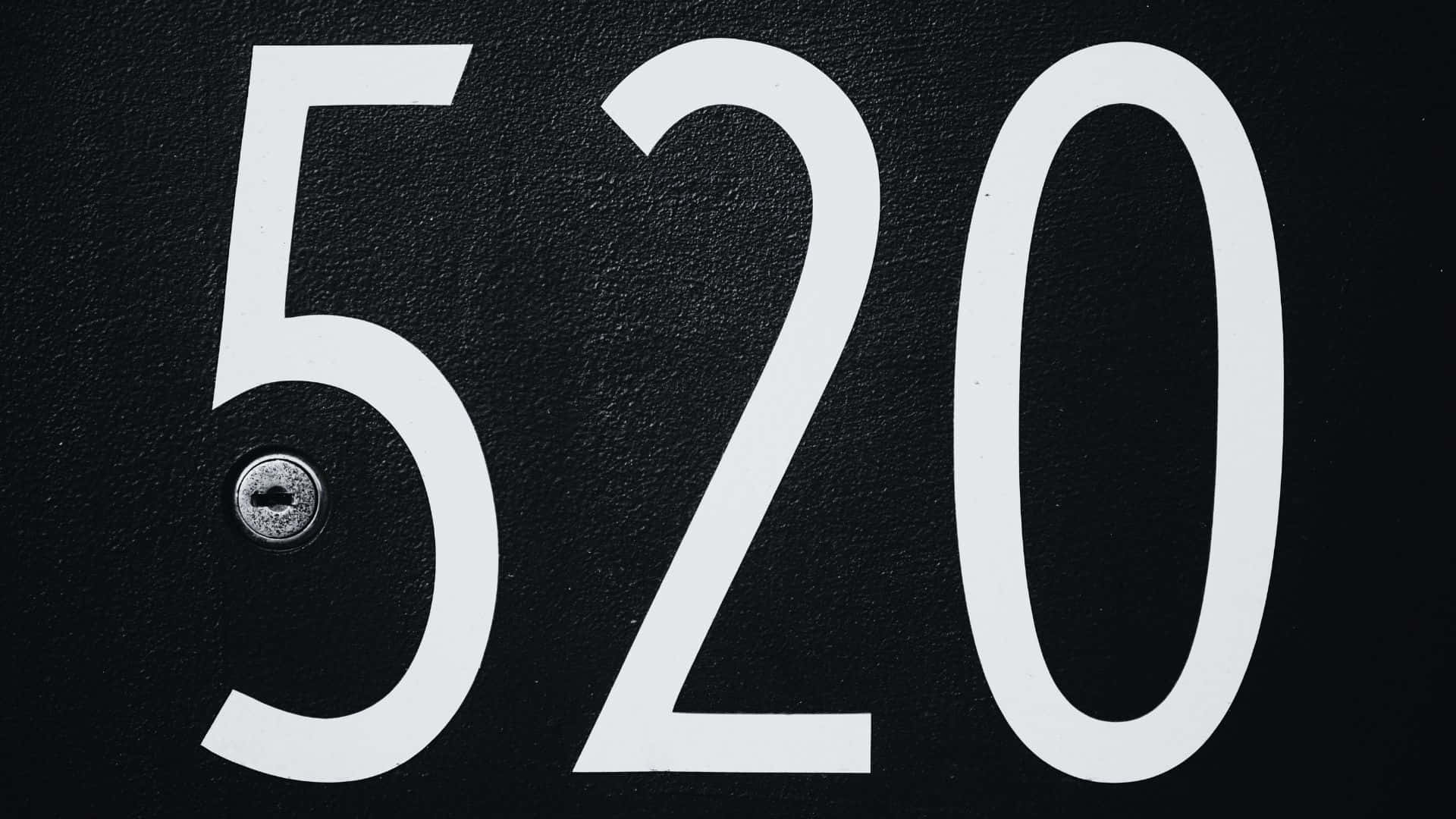 Black And White Number 桌布 壁紙 — 粗體白色數字520在帶有紋理的黑色表面上突出顯示，五字下方有一個小的金屬鑰匙孔。