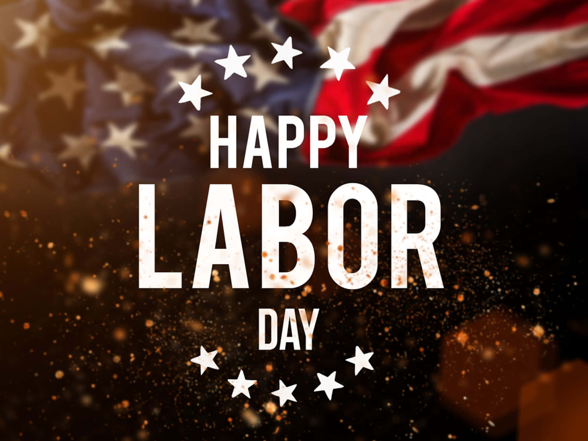 勞動節 桌布 壁紙 — 粗體白色文字寫著 happy labor day，被星星環繞，背景是飄揚的美國國旗，帶有金色閃光。