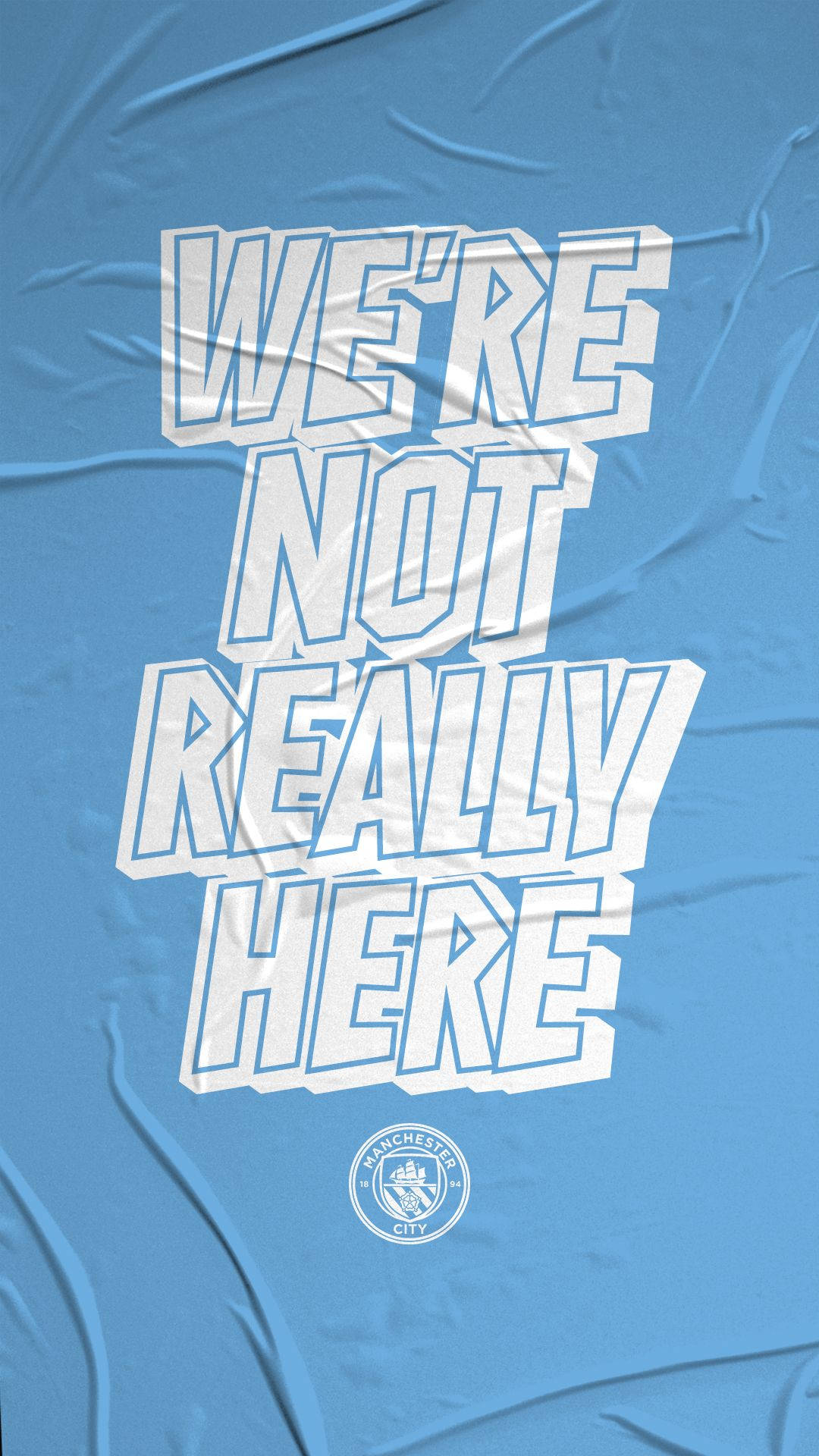 曼徹斯特城 桌布 壁紙 — 粗體白色文字寫著「WE'RE NOT REALLY HERE」，位於皺巴巴的淺藍色布料上，下方有一個細小的曼城標誌。