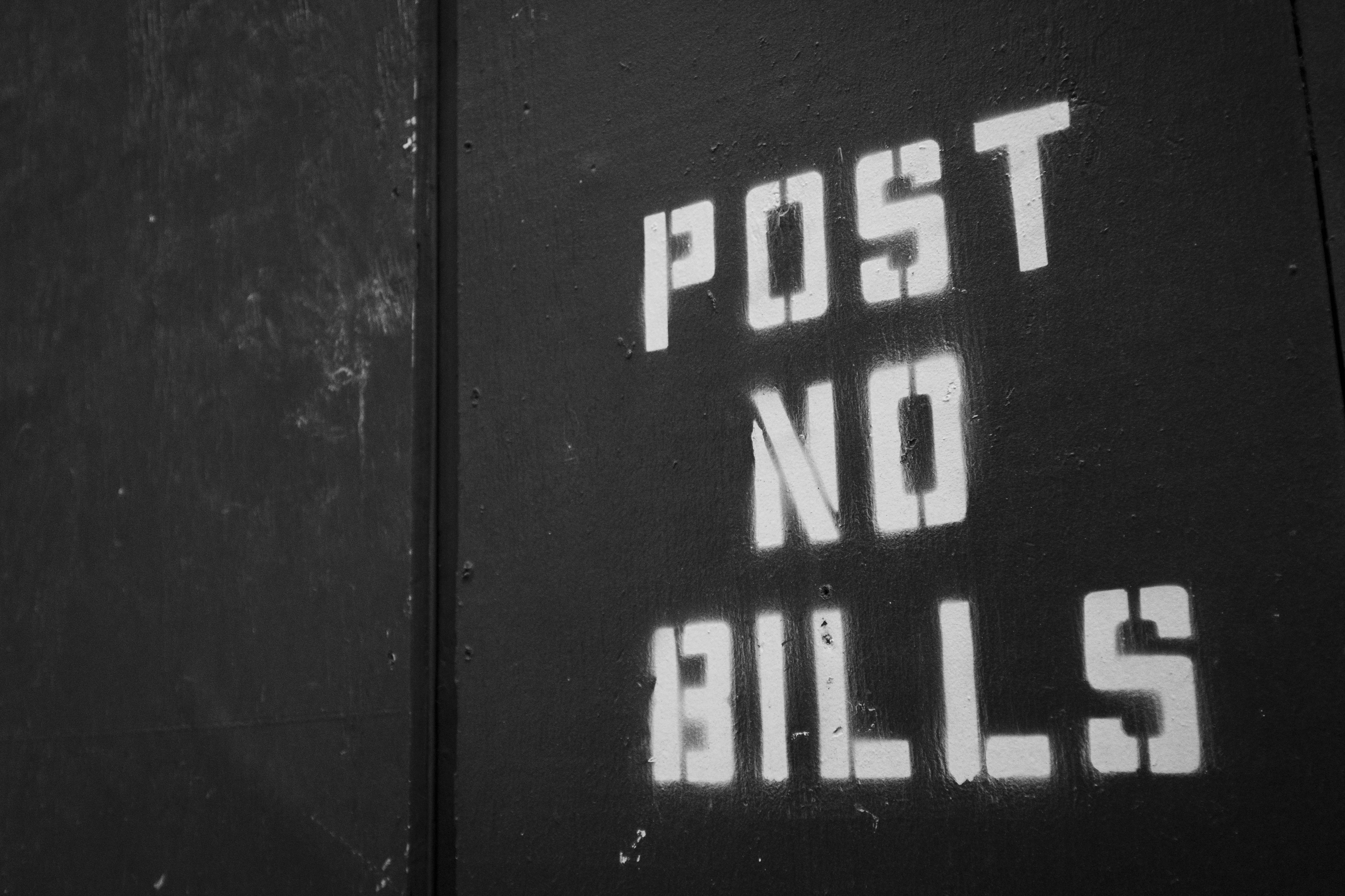 New 桌布 壁紙 — 粗體白色模板文字寫著「POST NO BILLS」，與風化的黑色金屬表面形成鮮明對比。