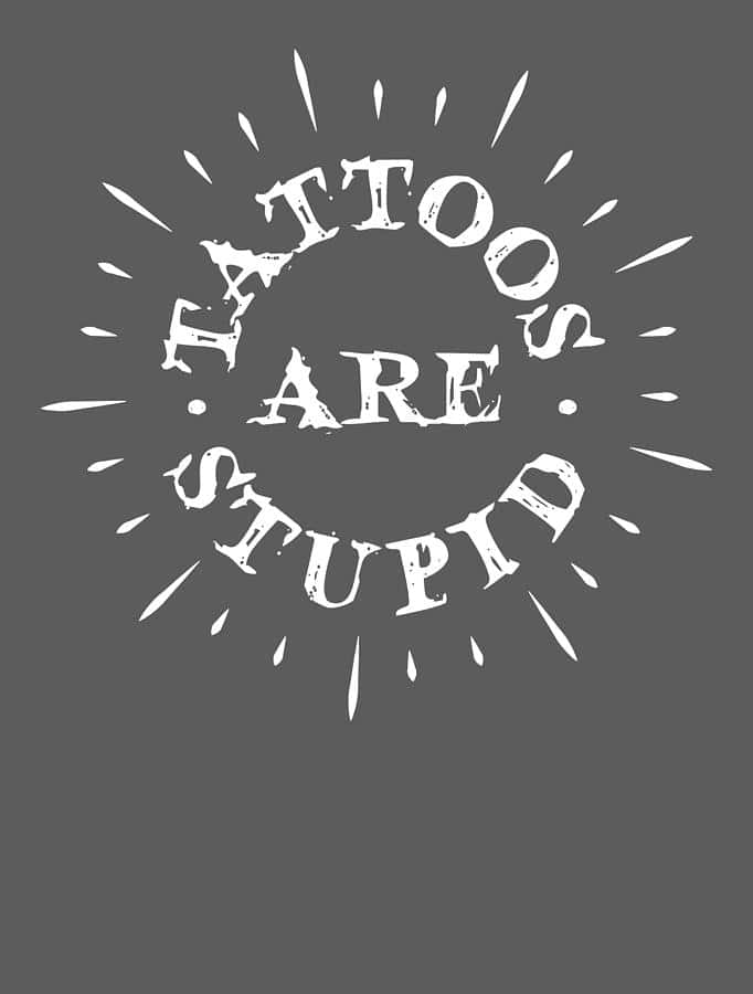 Stupid 桌布 壁紙 — 粗體白色磨損文字在純灰色背景上帶有放射線，宣告刺青是愚蠢的。