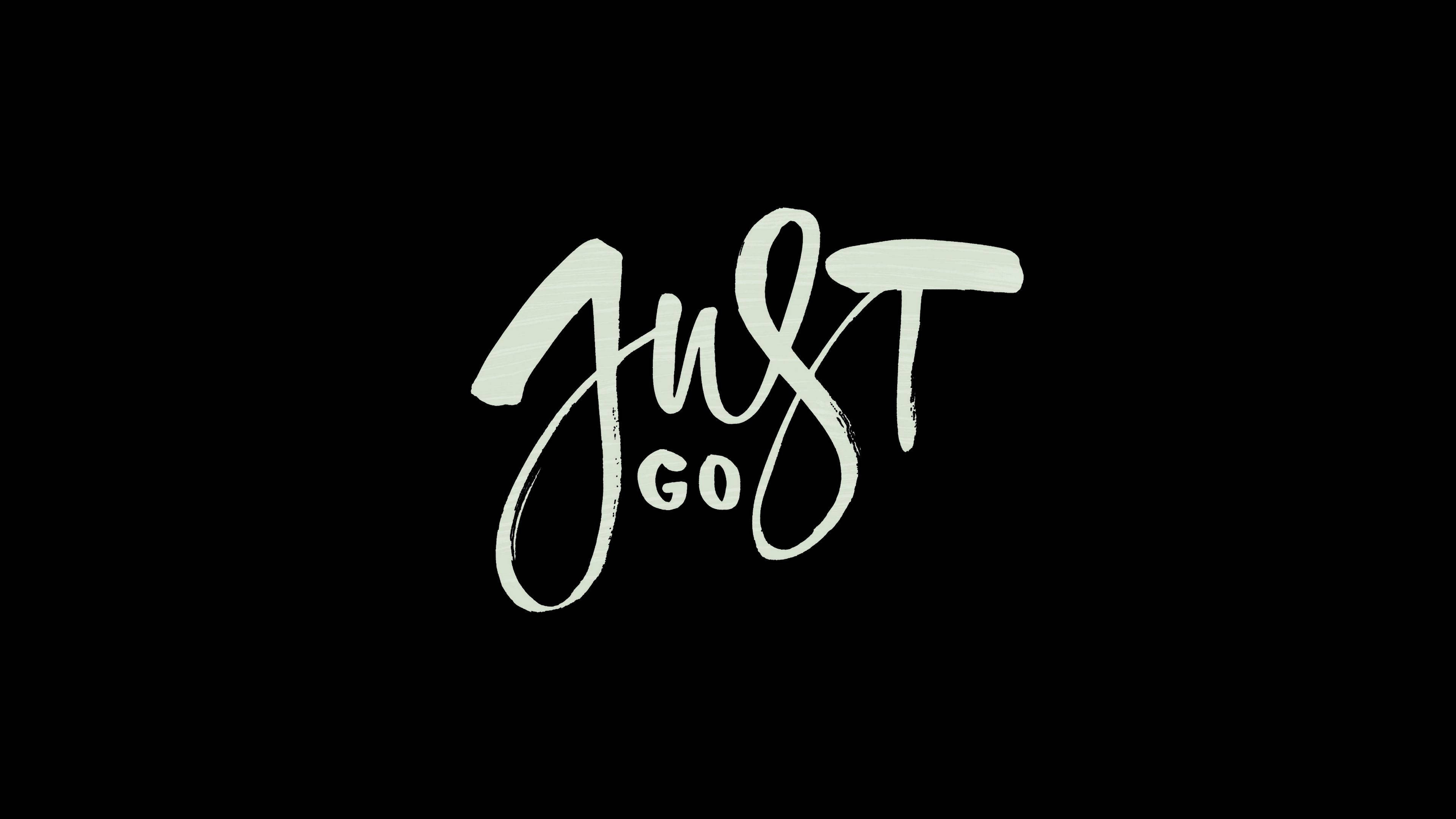 桌布 壁紙 — 粗體白色筆觸字母在純黑色背景上拼寫出「JUST GO」。