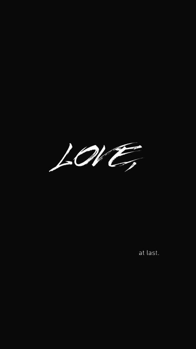 Love Quote 桌布 壁紙 — 粗體白色筆觸文字「LOVE at last」居中顯示在純黑色背景上。