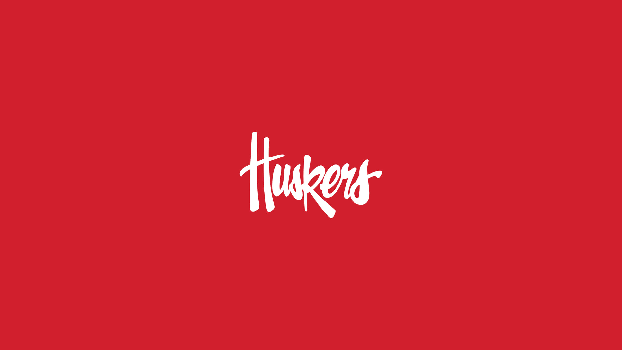 桌布 壁紙 — 粗體白色草書Huskers標誌居中於純深紅色背景上。