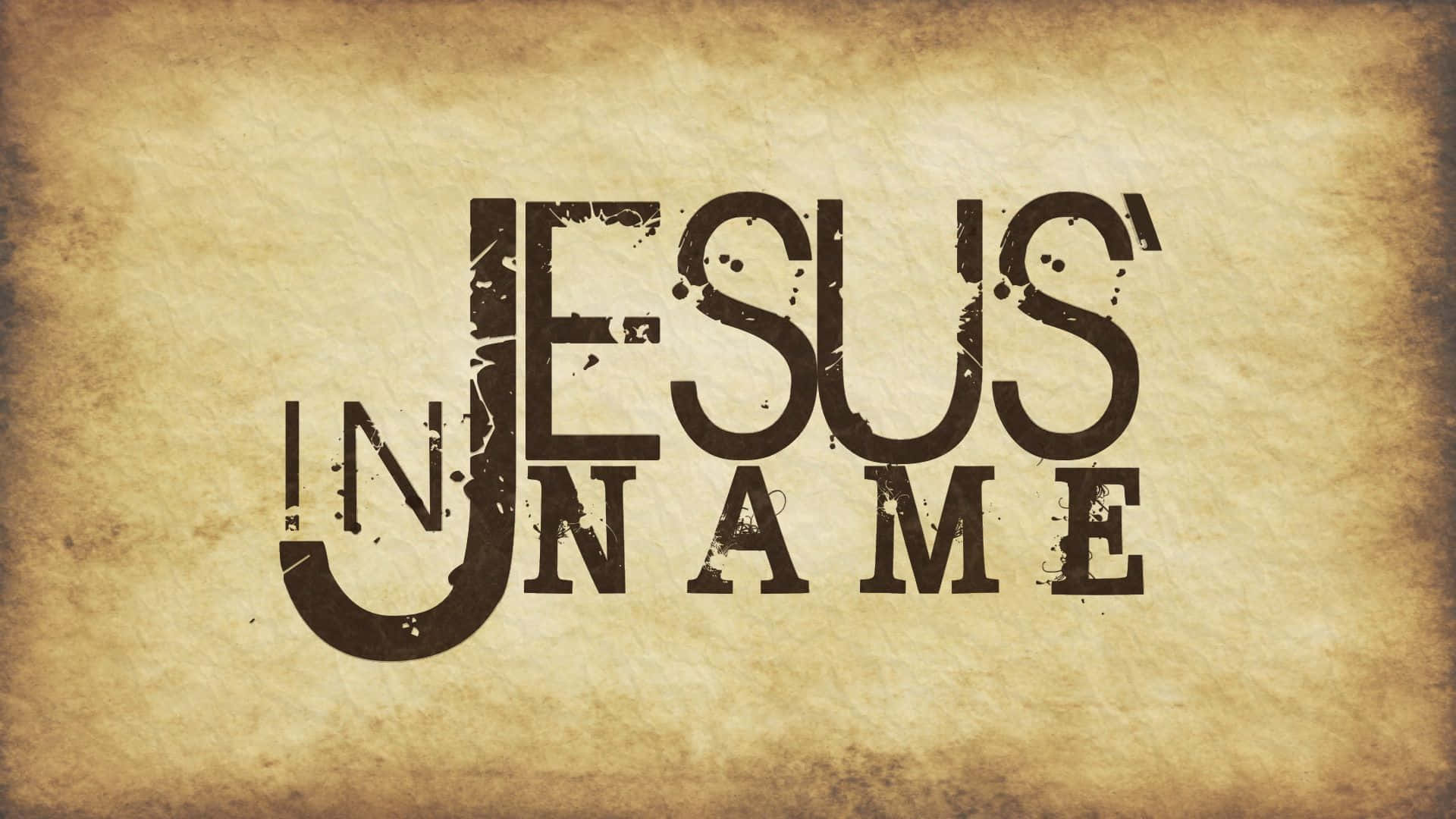 Jesus Name 桌布 壁紙 — 粗體磨損文字在帶有復古質感和溫暖棕褐色調的舊羊皮紙上寫著「IN JESUS' NAME」。