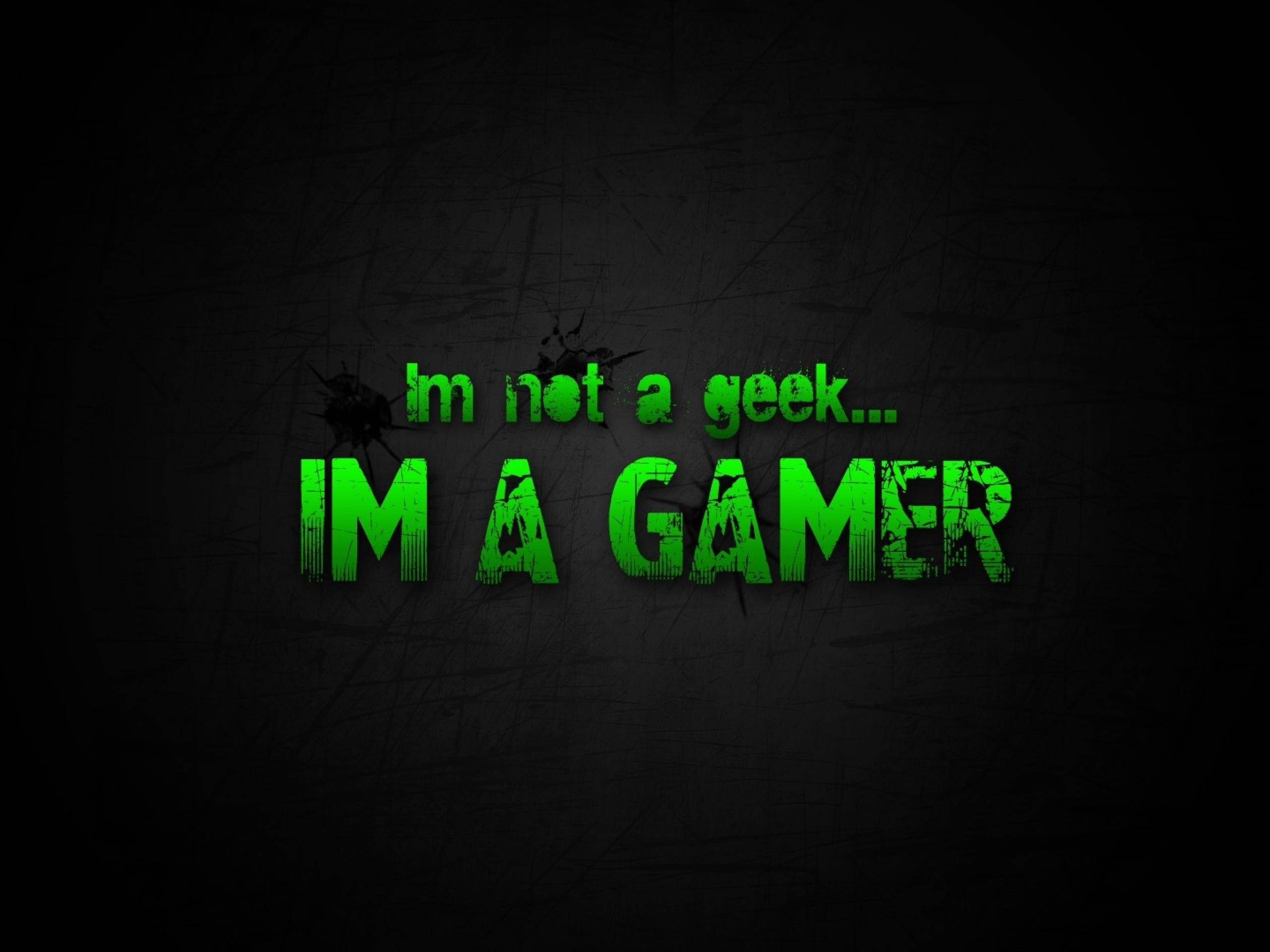 Profile 桌布 壁紙 — 粗體綠色文字在刮花的黑色背景上宣告「I'm not a geek... I'M A GAMER」。