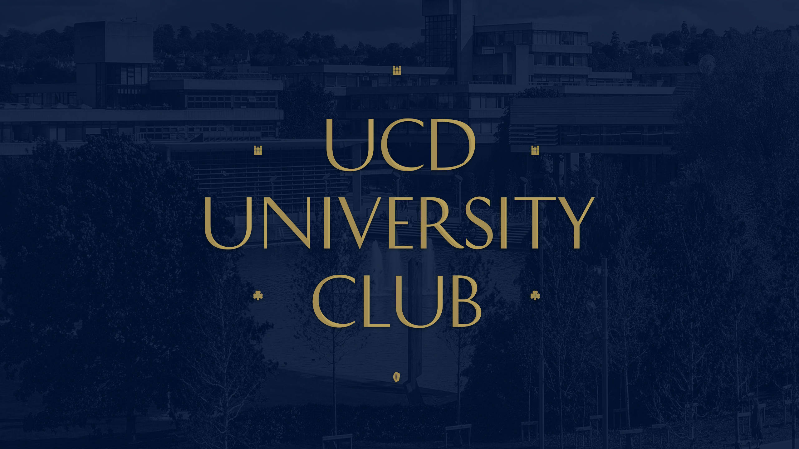 桌布 壁紙 — 粗體金色文字 UCD UNIVERSITY CLUB 出現在深藍色濾鏡效果的校園場景上，有樹木和建築物。