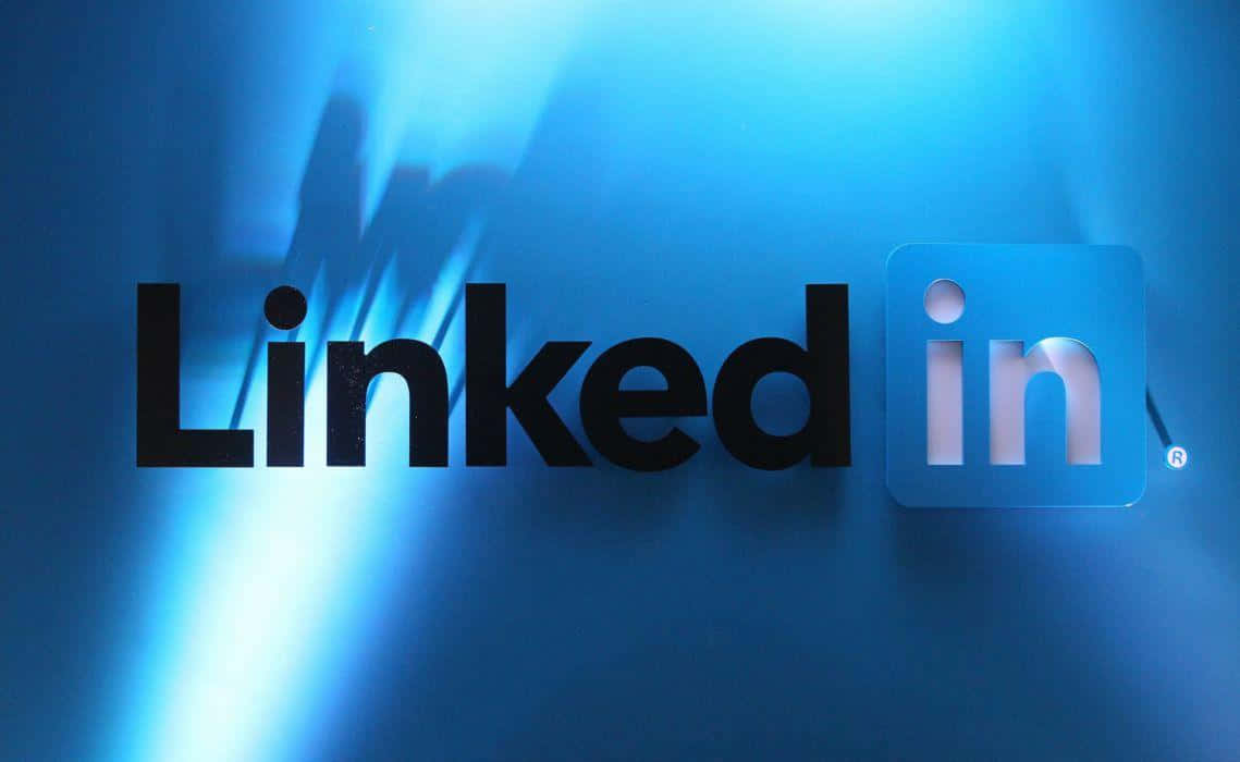 Logo Design 桌布 壁紙 — 粗體黑色和藍色的LinkedIn標誌在帶有光線條紋的耀眼藍色漸變背景上發光。