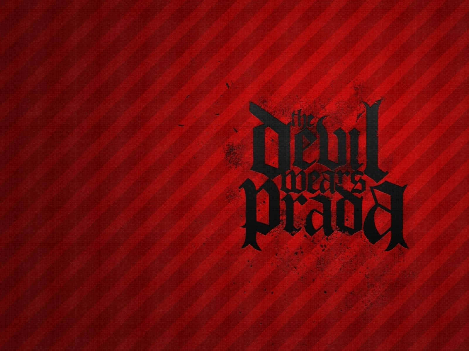 Prada 桌布 壁紙 — 粗體黑色哥德式文字在帶有飛濺效果的鮮紅色對角線條紋背景上顯示「the devil wears prada」。