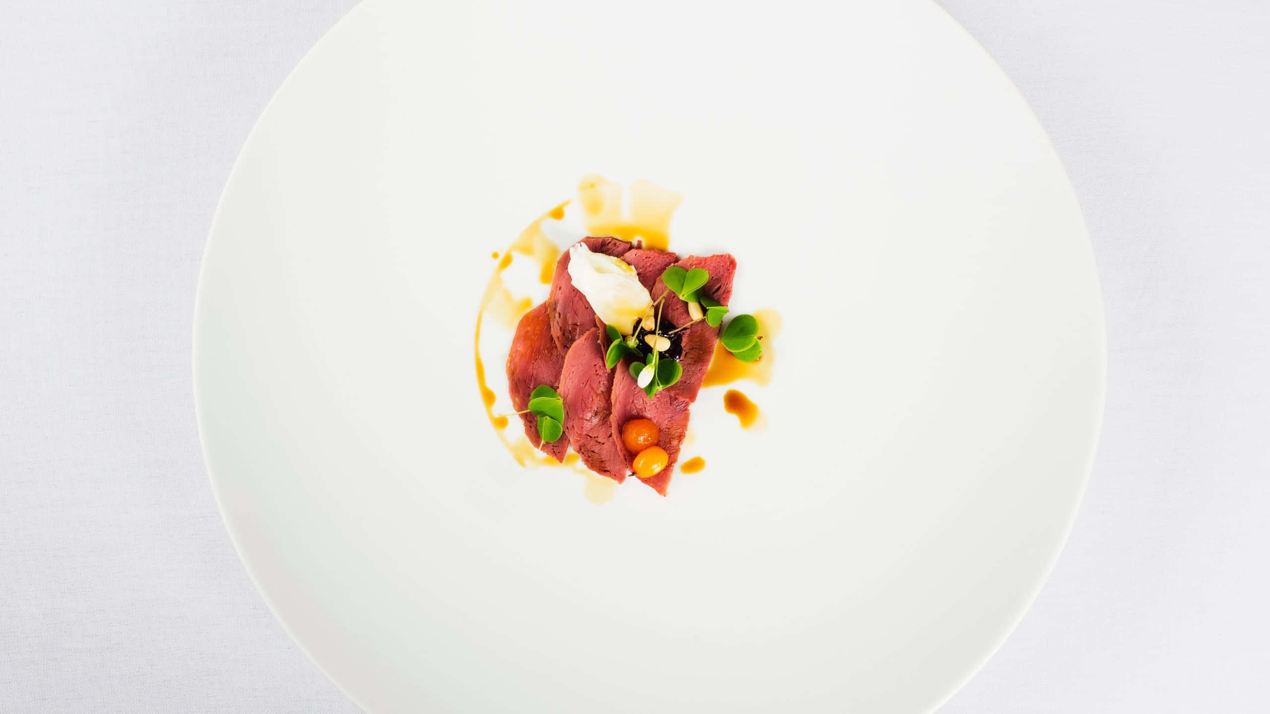 Delicious Food 桌布 壁紙 — 精心擺盤的炙燒牛肉料理，搭配醬汁、微型蔬菜和裝飾，置於白色餐盤上。