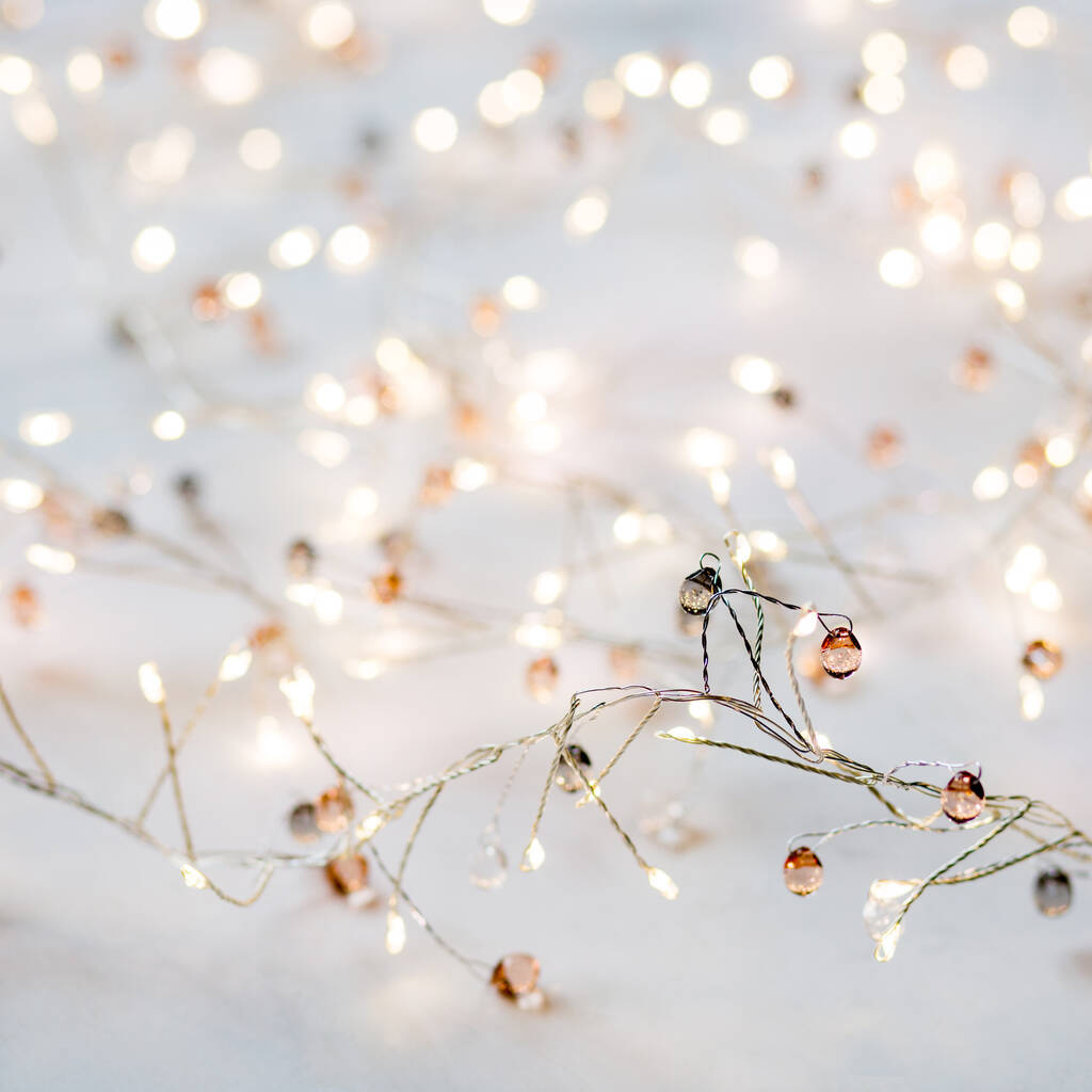 Fairy Lights Aesthetic 桌布 壁紙 — 精緻的仙女燈，帶有溫暖發光的燈泡和銅色點綴，在柔和的白色背景上輕輕閃爍。