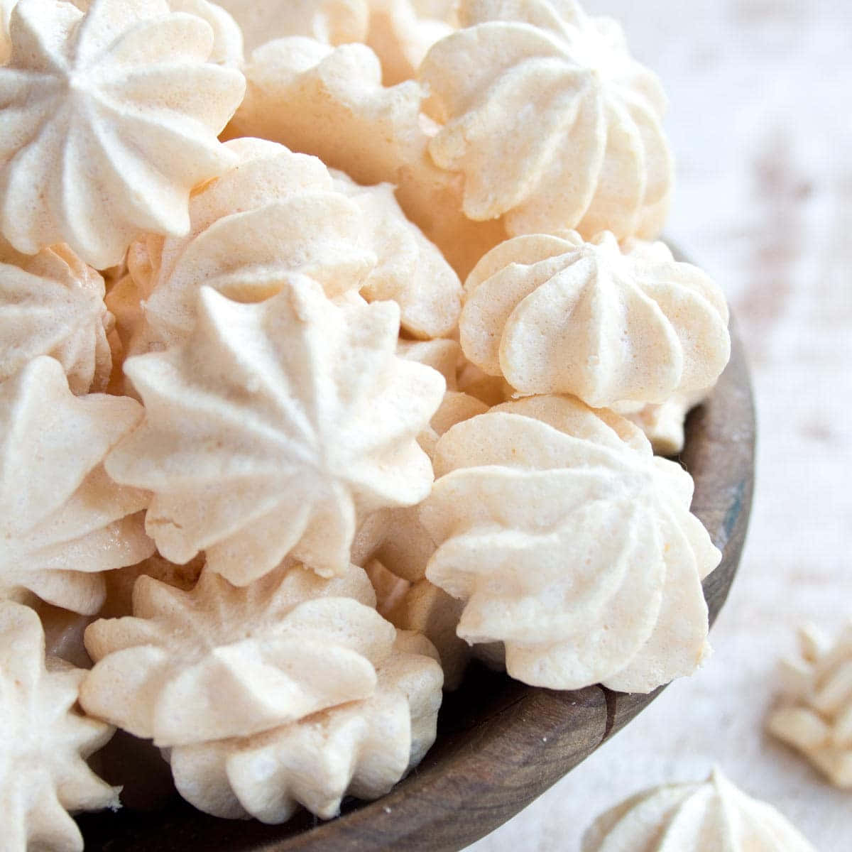 Meringue 桌布 壁紙 — 精緻的奶油色蛋白脆餅堆放在質樸的木碗中的特寫。
