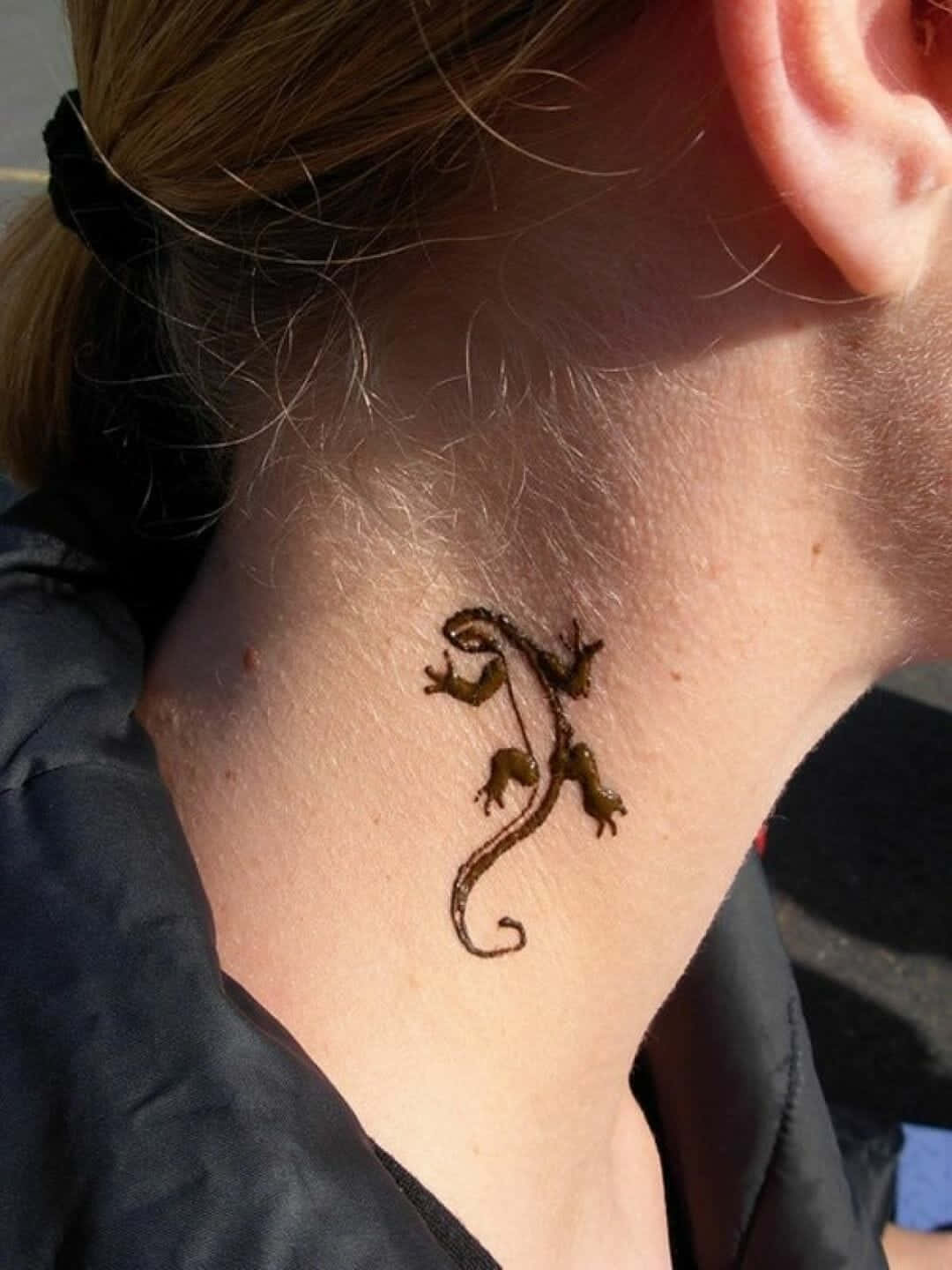 Tattoo 桌布 壁紙 — 精緻的棕色蜥蜴刺青優雅地蜷曲在一個人的脖子上，在明亮的陽光下。