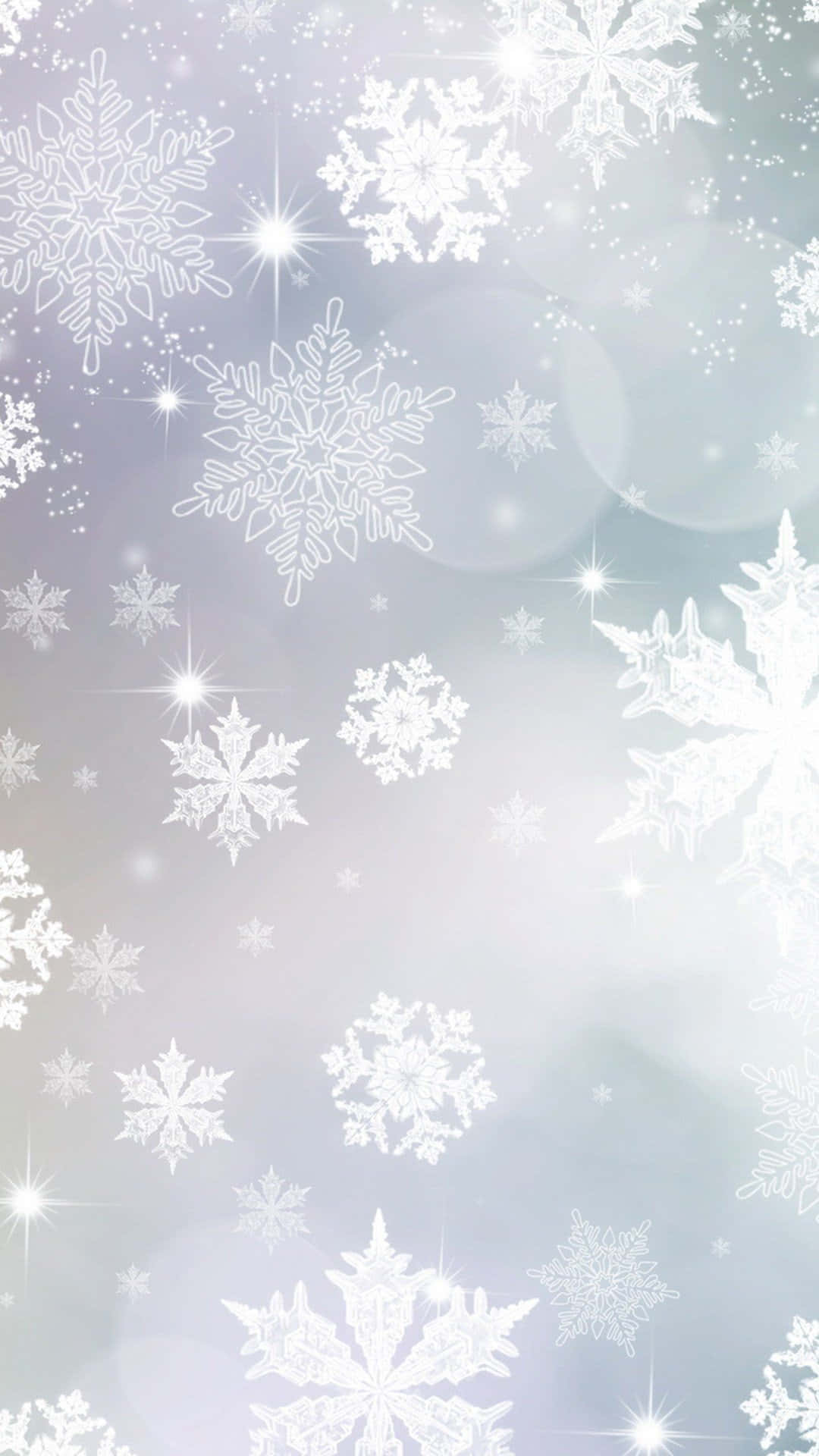 聖誕節 桌布 壁紙 — 精緻的白色雪花在柔和的漸層天空中飄動，伴隨著閃爍的星芒和散景光。