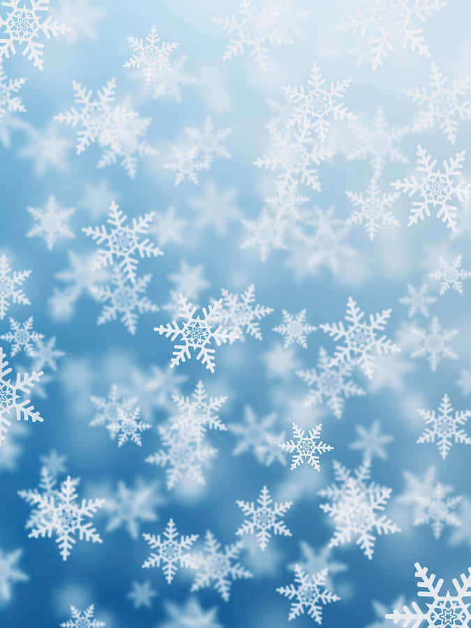 雪 桌布 壁紙 — 精緻的白色雪花在柔和的漸層藍色天空背景下輕輕飄落。