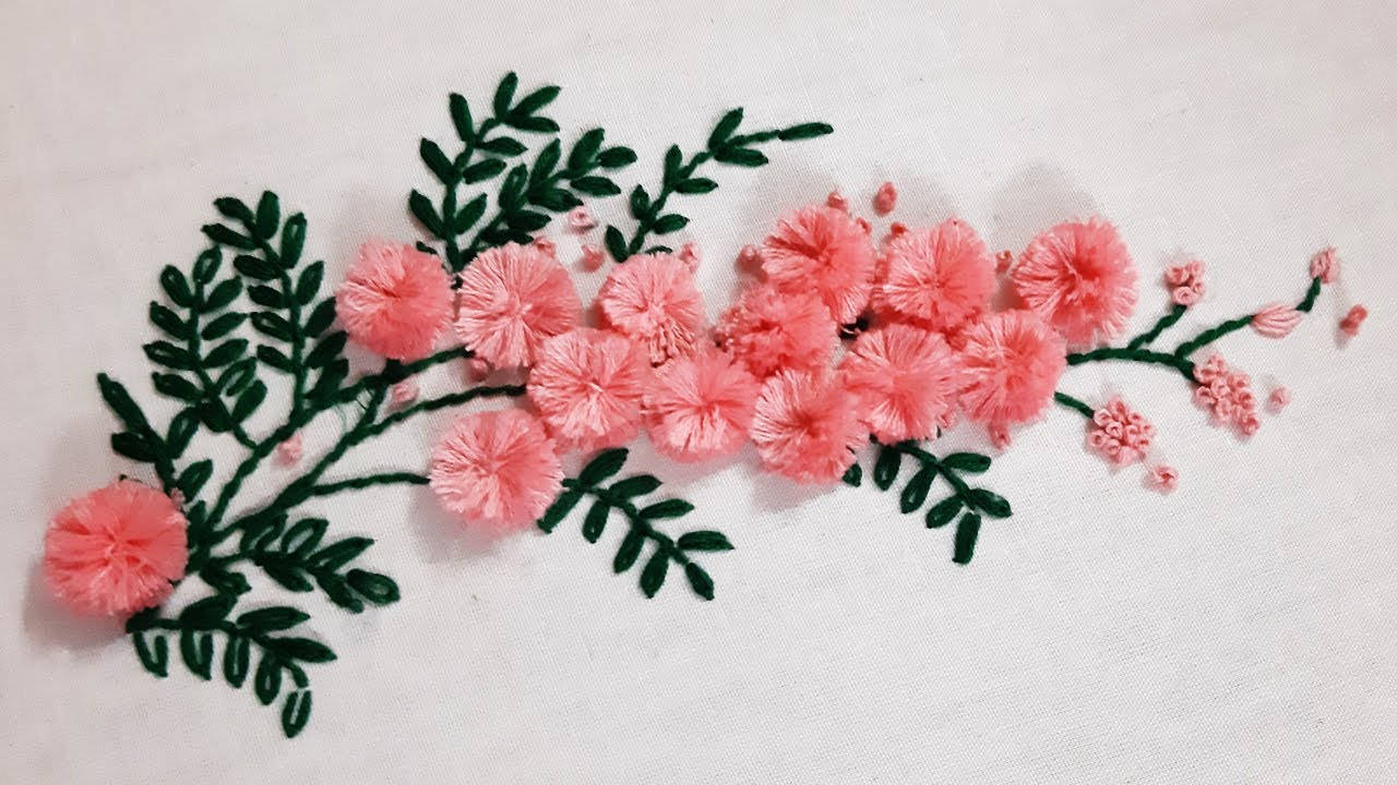 mimosa 桌布 壁紙 — 精緻的粉紅色花卉刺繡，帶有綠色葉子，縫在白色布料背景上。