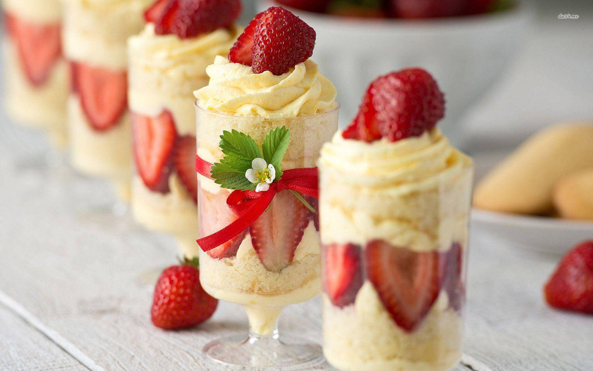 Desserts 桌布 壁紙 — 精緻的草莓芭菲放在玻璃杯中，上面加上鮮奶油和新鮮草莓，置於鄉村風木桌上。