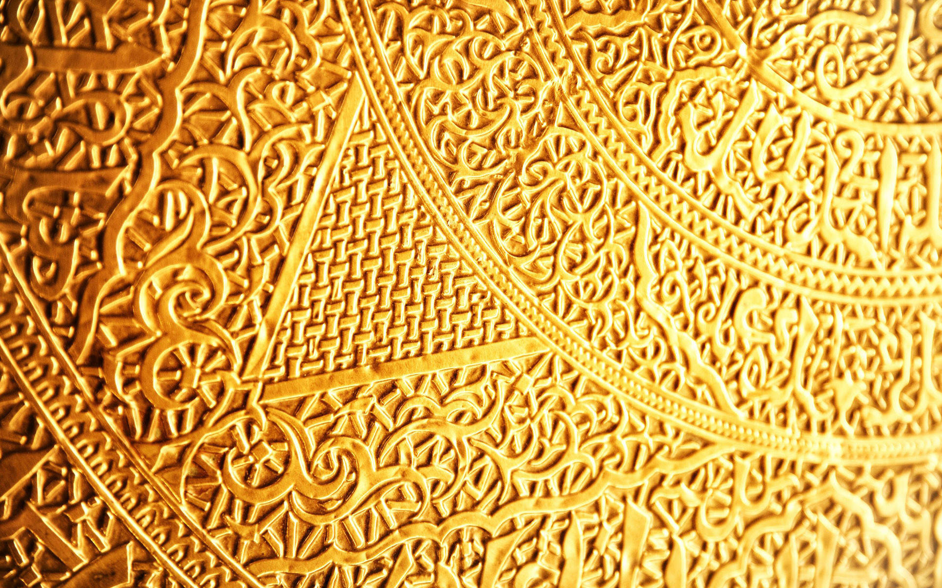 Foil 桌布 壁紙 — 精緻金色伊斯蘭幾何圖案和書法圖案的近距離特寫，帶有浮雕細節和溫暖燈光。