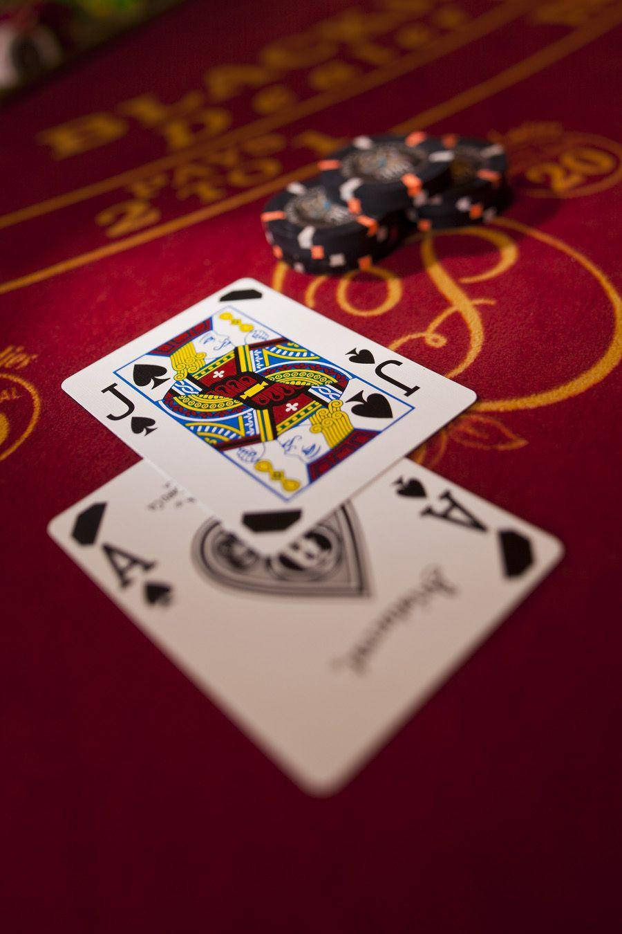 Casino 桌布 壁紙 — 紅底金色標記的賭桌上，皇后與黑桃Ace撲克牌和籌碼的特寫。