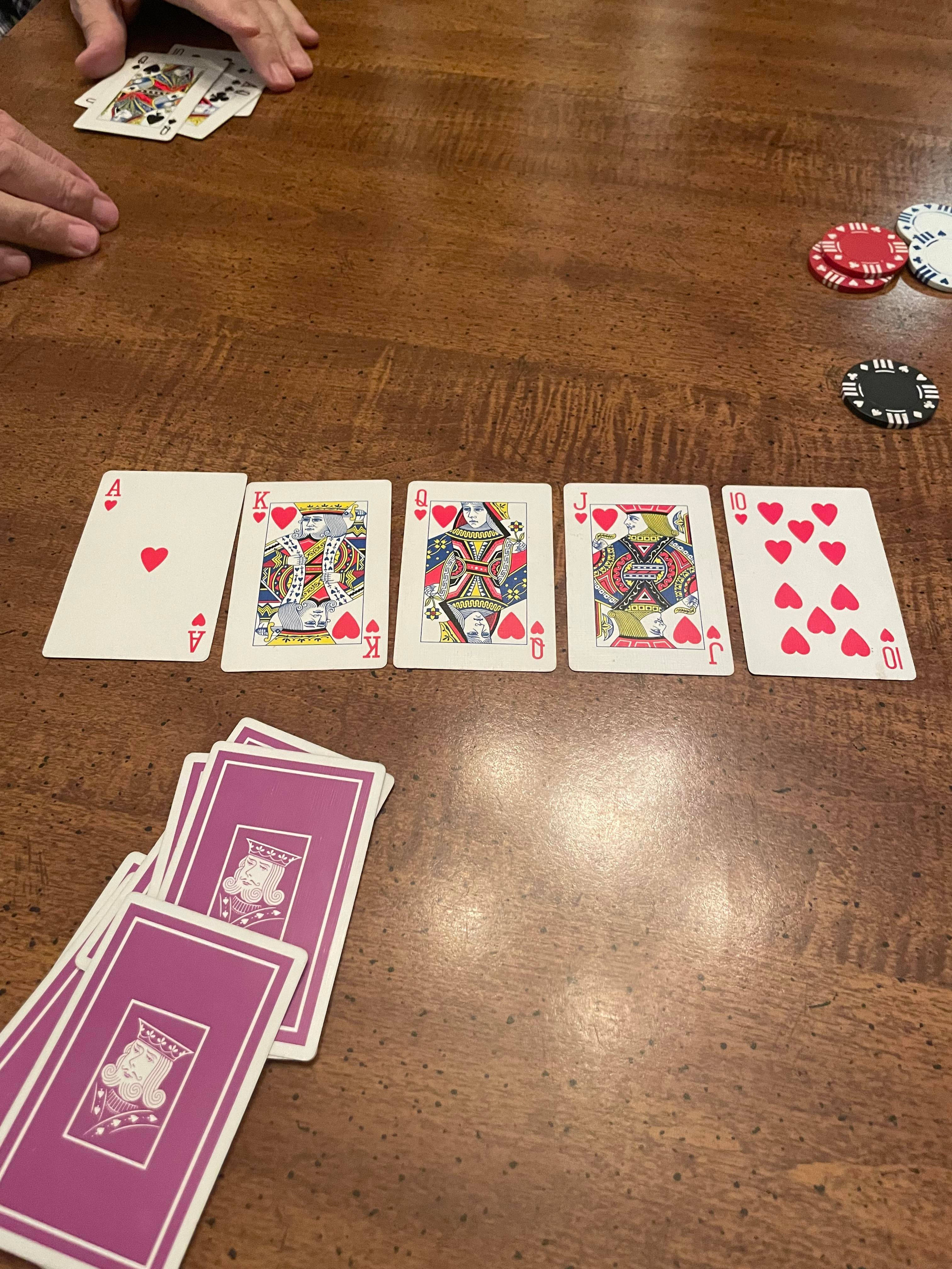 Cards 桌布 壁紙 — 紅心同花順牌放在木桌上，附近有籌碼和手。