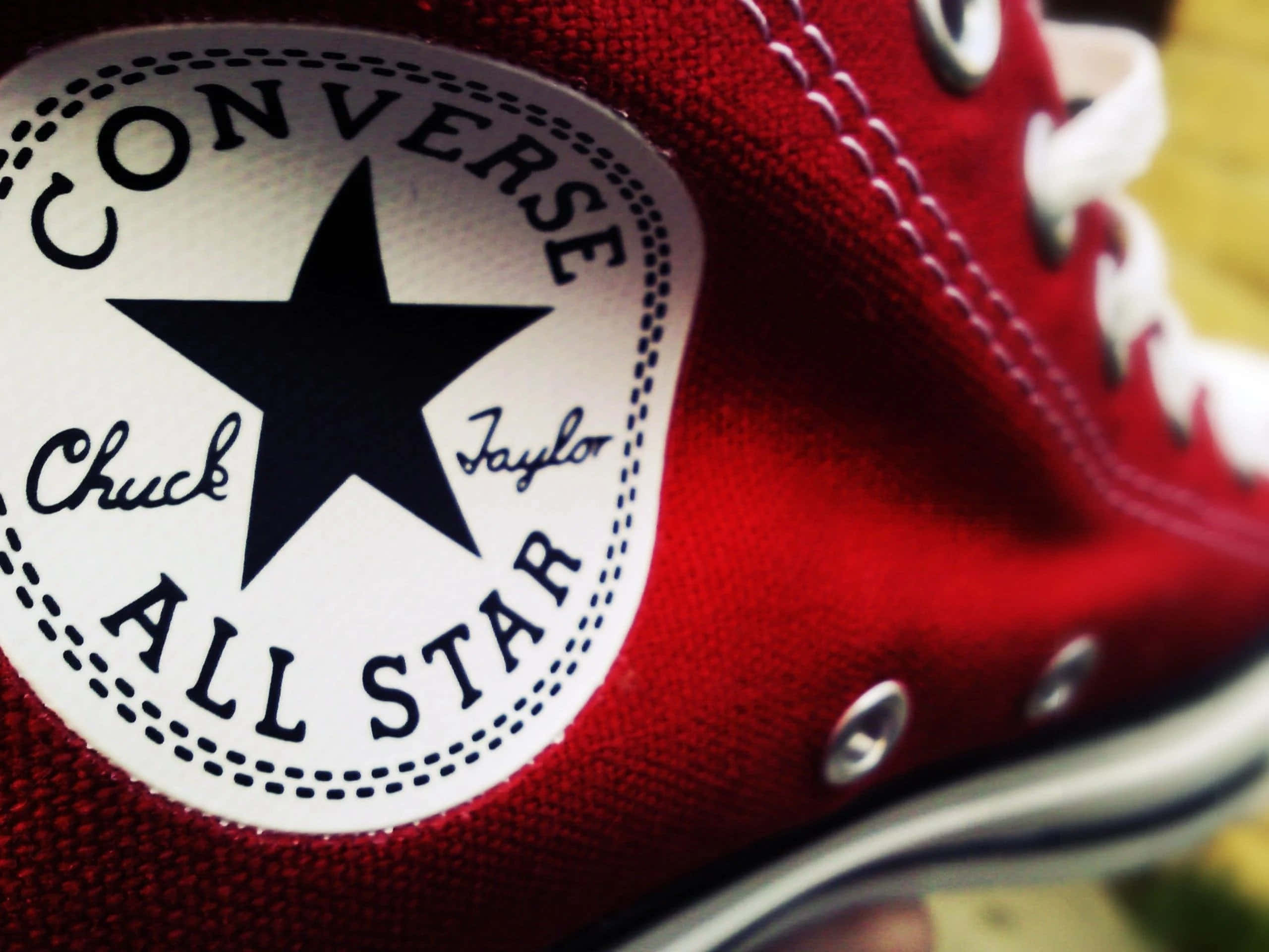 Converse Logo 桌布 壁紙 — 紅色 Converse Chuck Taylor All Star 運動鞋特寫，突顯標誌性的星星標誌和白色鞋帶。