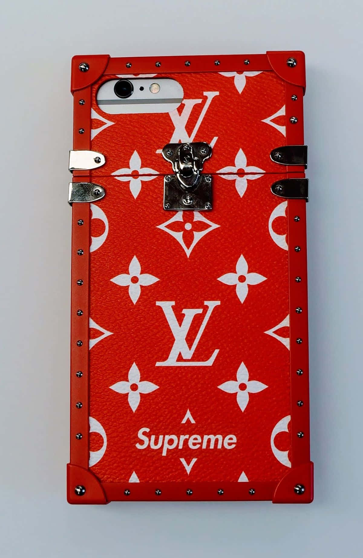 supreme 桌布 壁紙 — 紅色 Louis Vuitton x Supreme 手機殼，帶有白色 monogram 圖案和銀色金屬配件，背景為純白色。