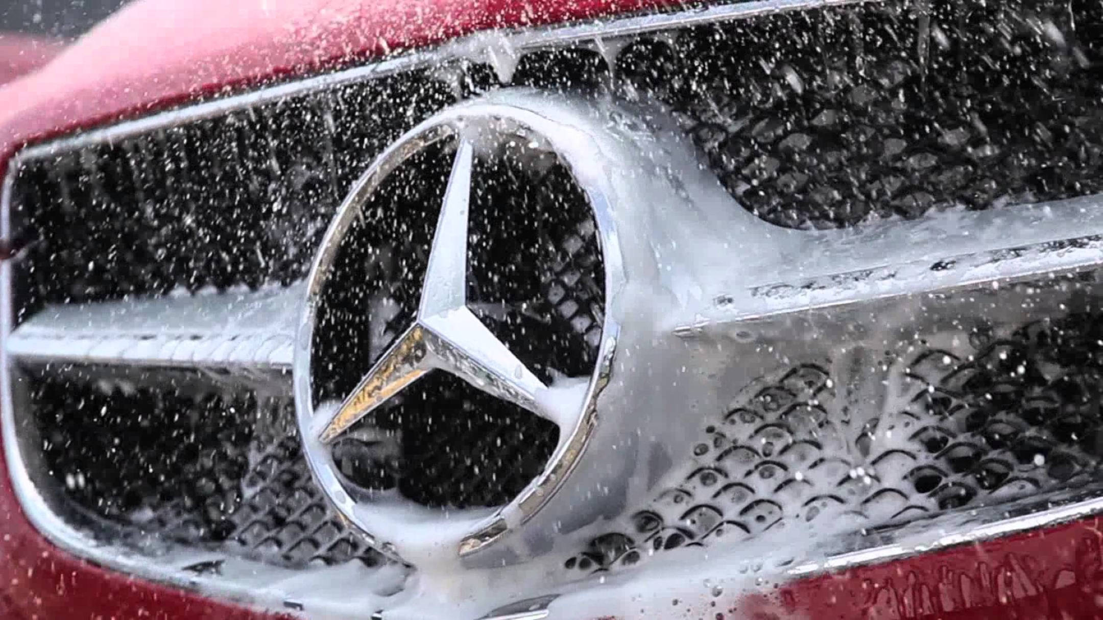 Wash 桌布 壁紙 — 紅色 Mercedes-Benz 水箱護罩的特寫，正在用肥皂水清洗，水滴在標誌性的三叉星徽標周圍飛濺。