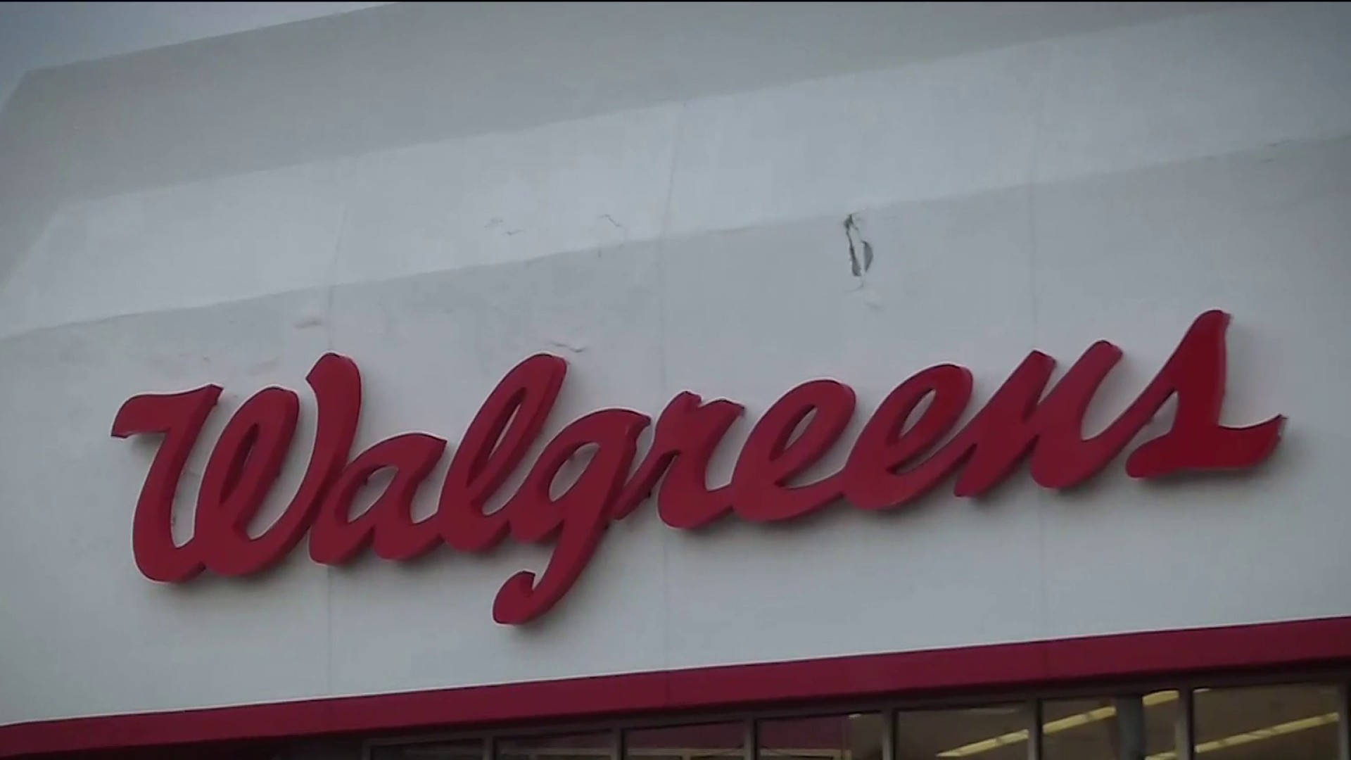 Business 桌布 壁紙 — 紅色 Walgreens 草書標誌安裝在白色建築物外牆上，天空多雲。
