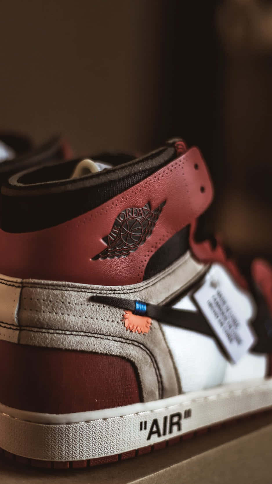 桌布 壁紙 — 紅色、白色和灰色的Jordan 1運動鞋特寫，帶有Off White品牌標誌和藍色標籤細節。