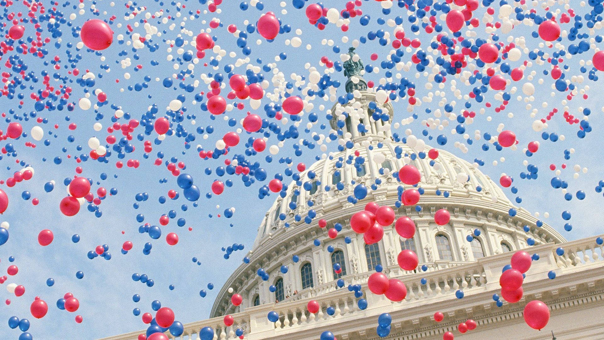 Independence 桌布 壁紙 — 紅色、白色和藍色的氣球在美國國會大廈圓頂上方的清澈藍天中大量漂浮。