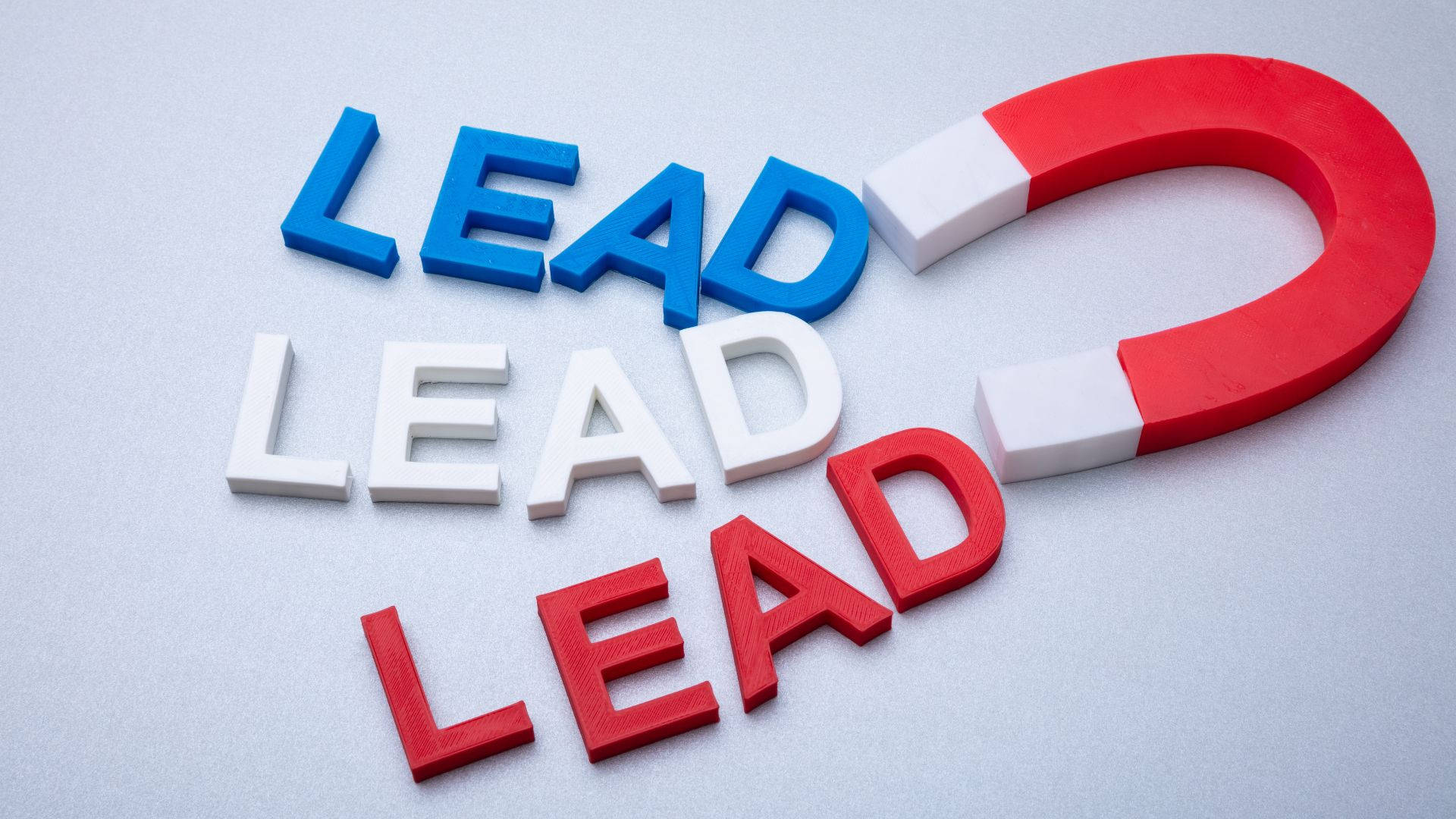 graphic design 桌布 壁紙 — 紅色、白色和藍色的立體「LEAD」字母排列成三角形，一個紅白相間的馬蹄形磁鐵正在拉動頂部的單詞。