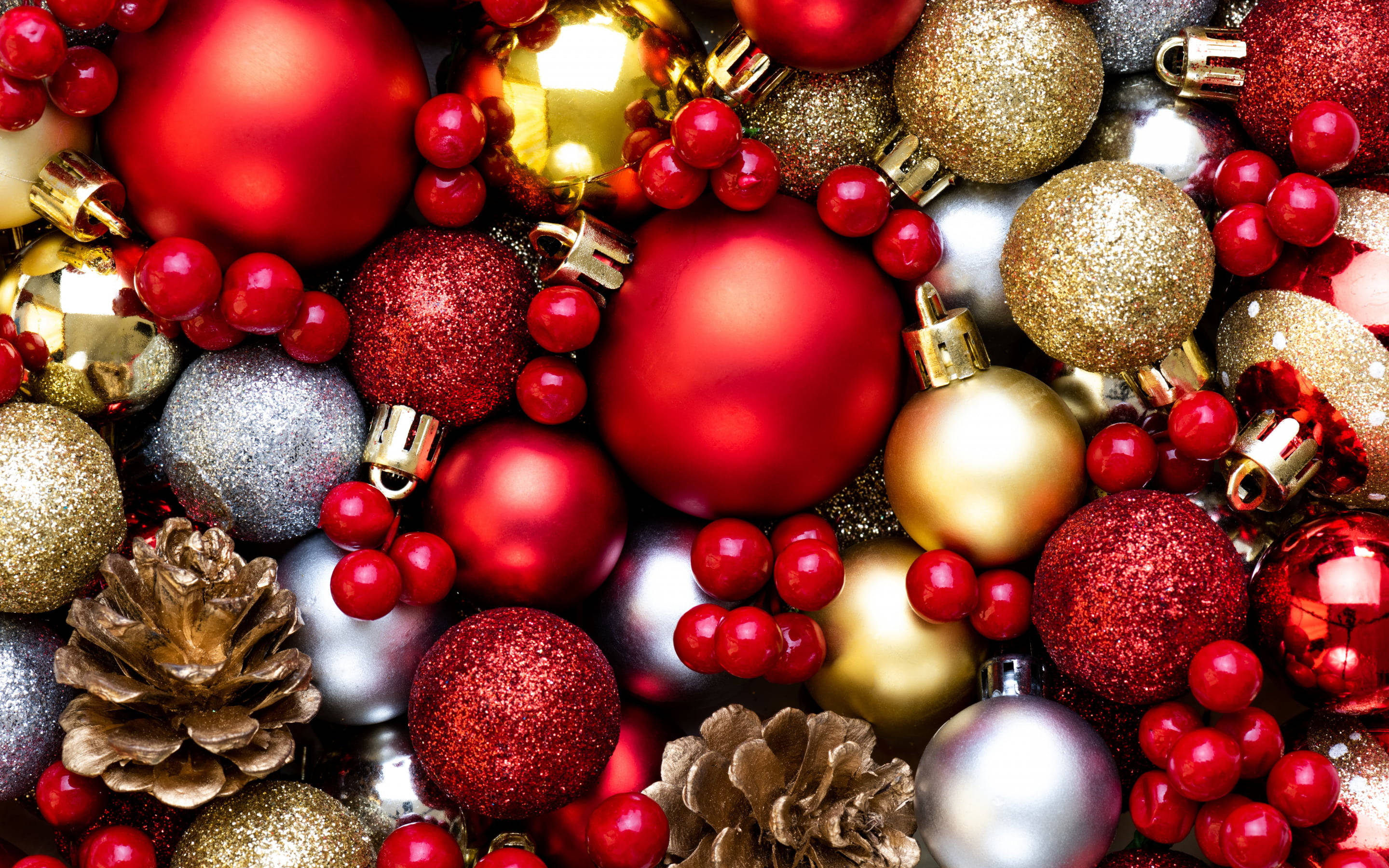 balls 桌布 壁紙 — 紅色、金色和銀色的聖誕裝飾品、松果和紅色漿果的特寫，營造出閃閃發光的節日質感。