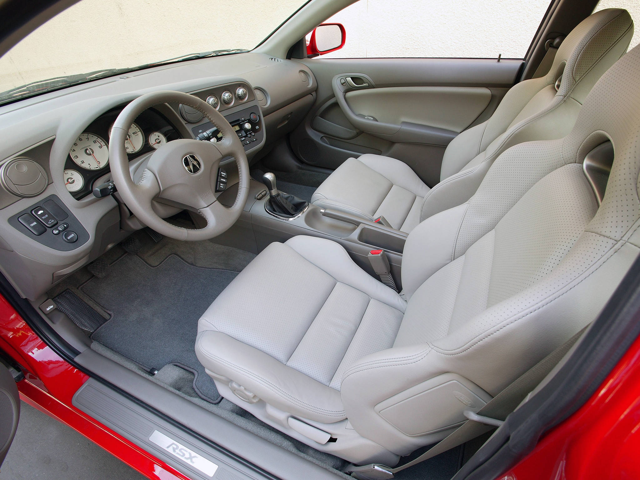 Acura 桌布 壁紙 — 紅色Acura RSX的內部，配以米色穿孔皮革座椅和灰色儀表板，在明亮的日光下。